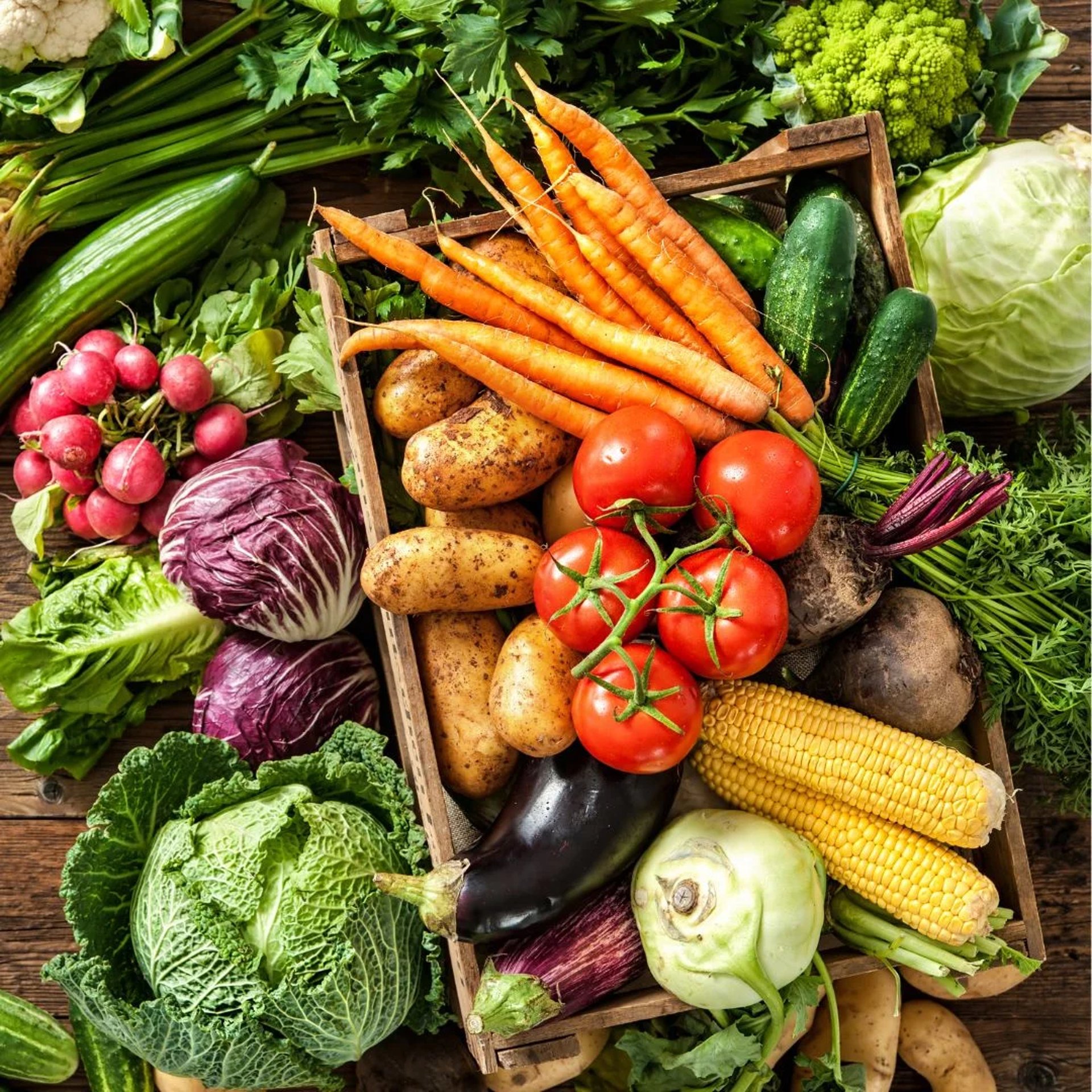 red apple fruit beside green vegetable on brown wooden crate