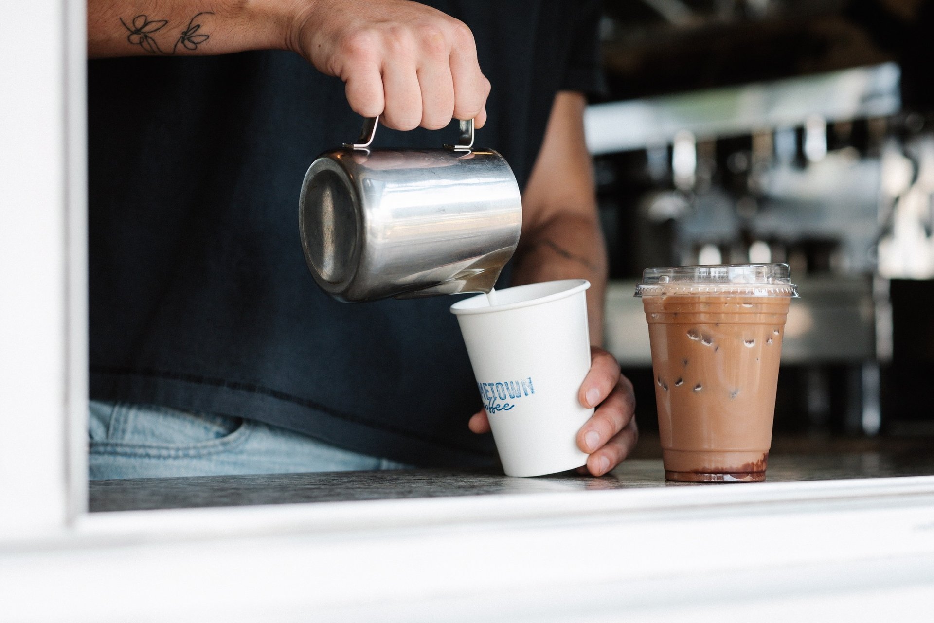 A person pouring a cup of coffee into a mug