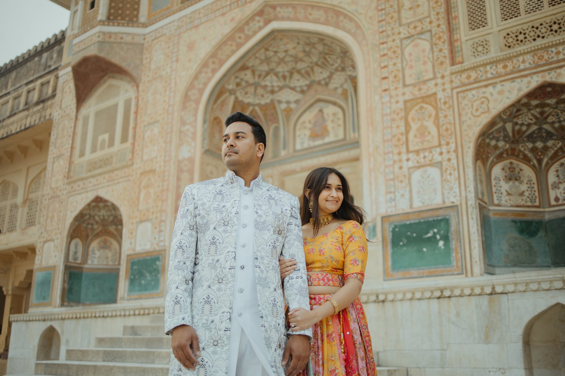 man and woman standing in front of brown concrete building during daytime