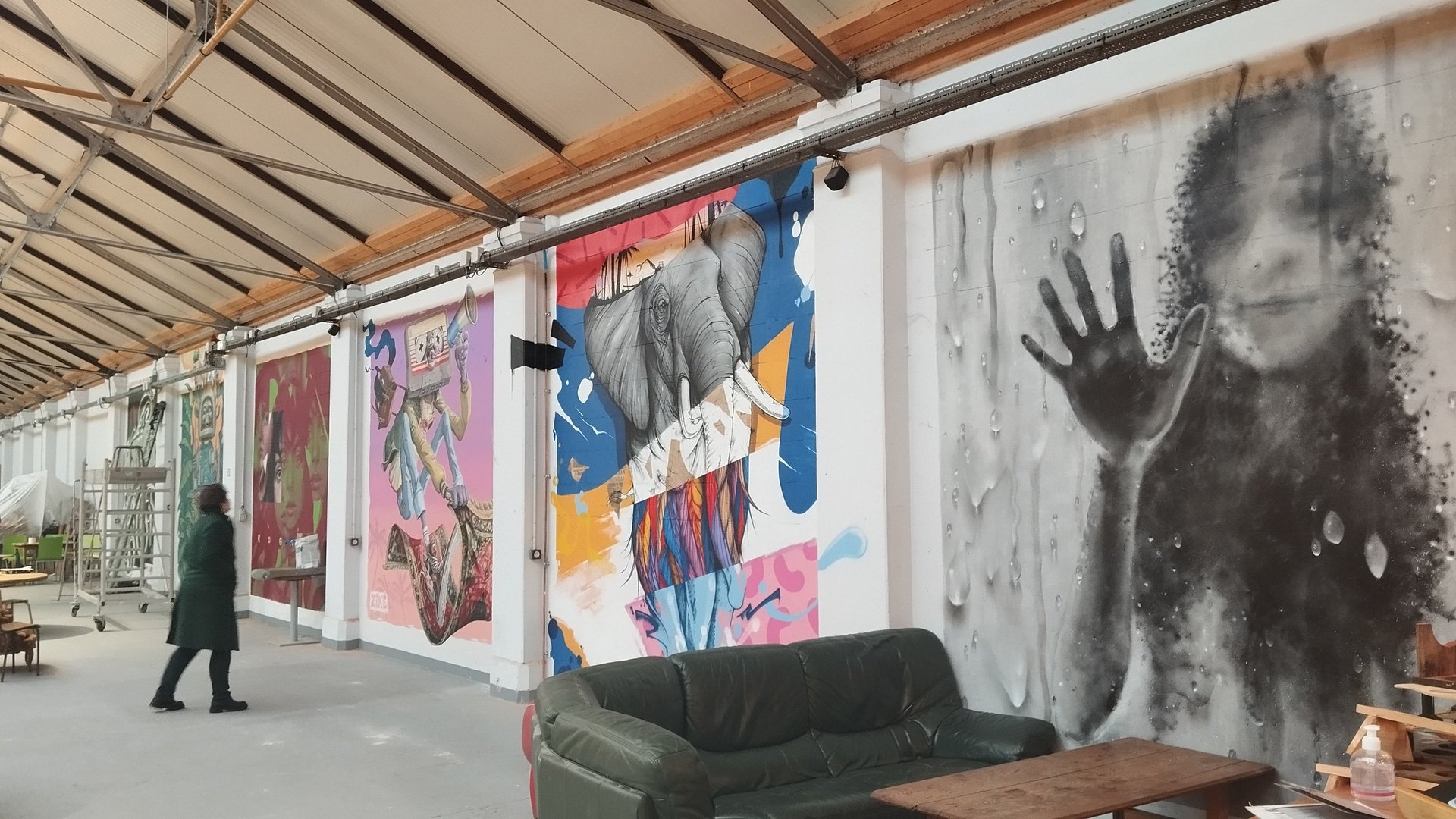 person wearing black bubble jacket watching wall posters