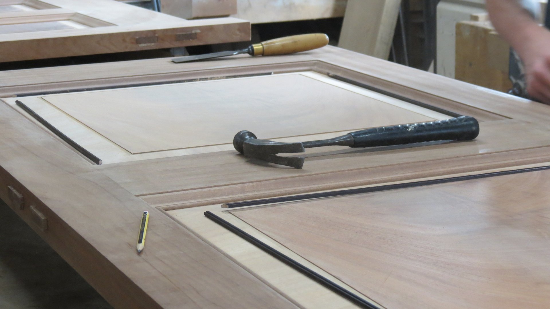 person using chisel while curving wood