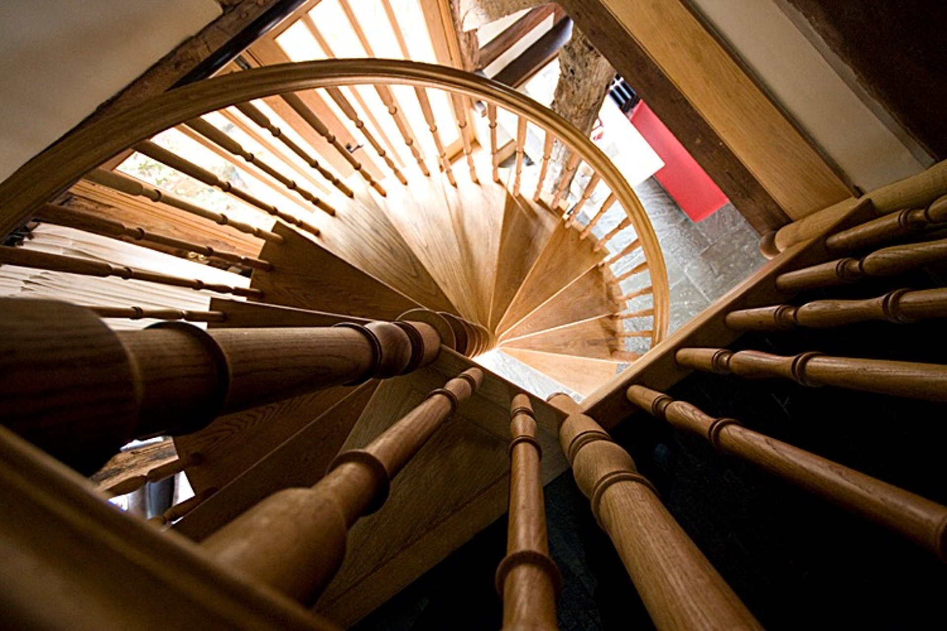 brown wooden spiral staircase with white wall