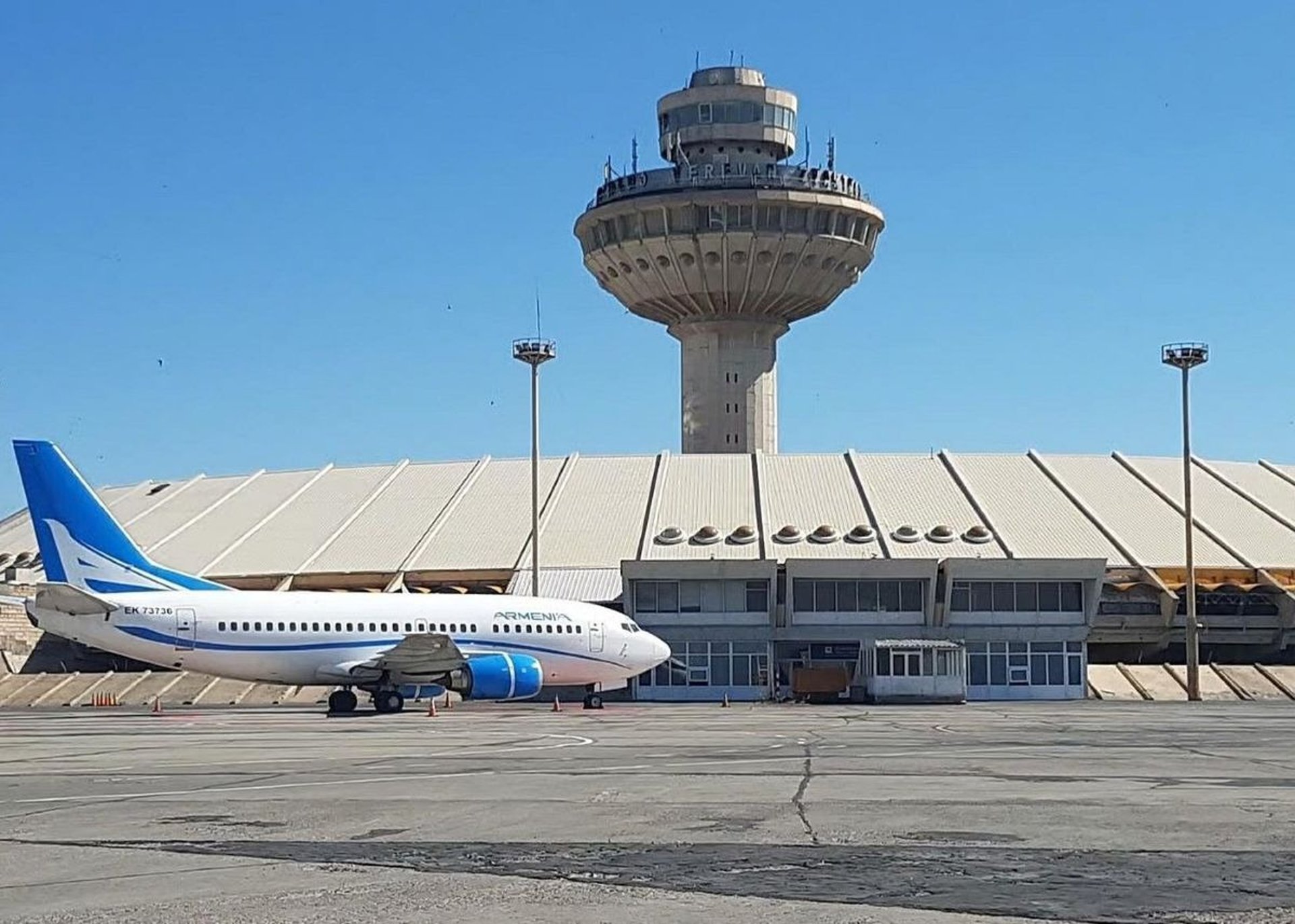 airplane flying over the city during sunset