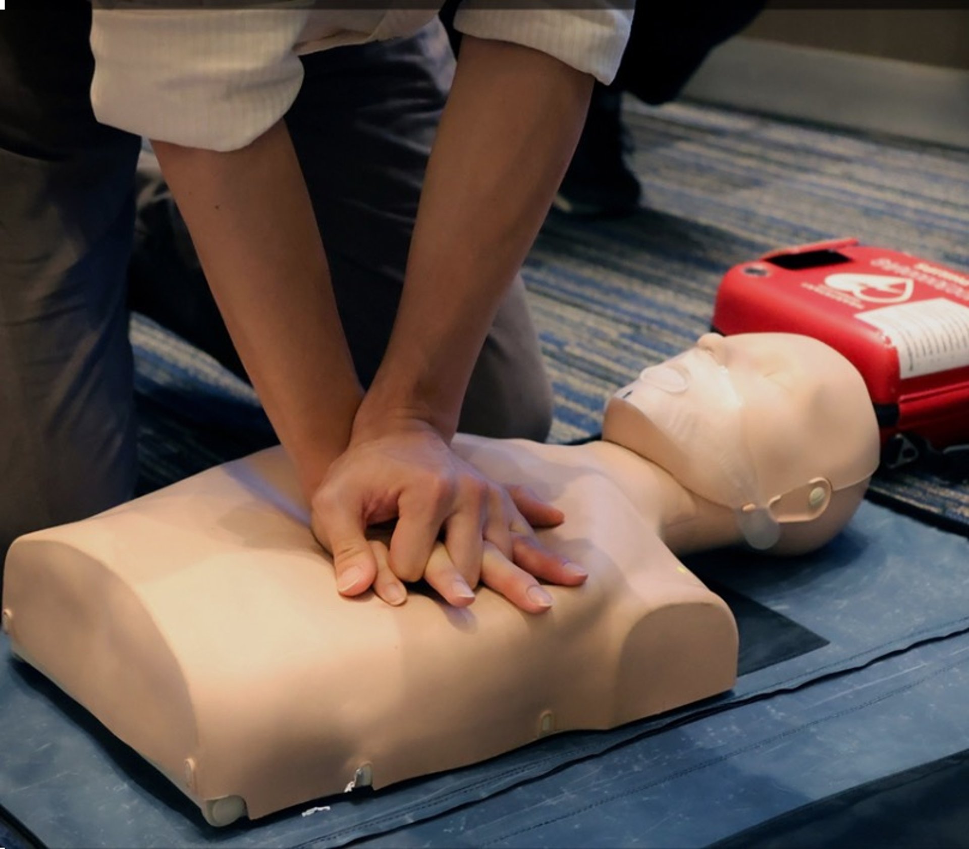 Man practices cpr on a training dummy outdoors