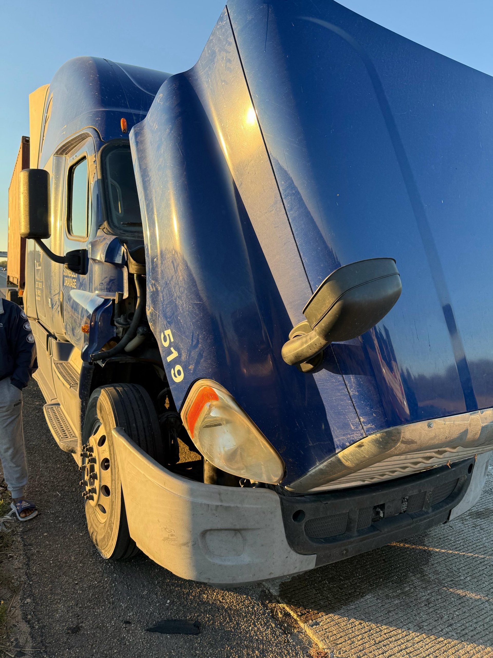 A red semi truck driving down a country road