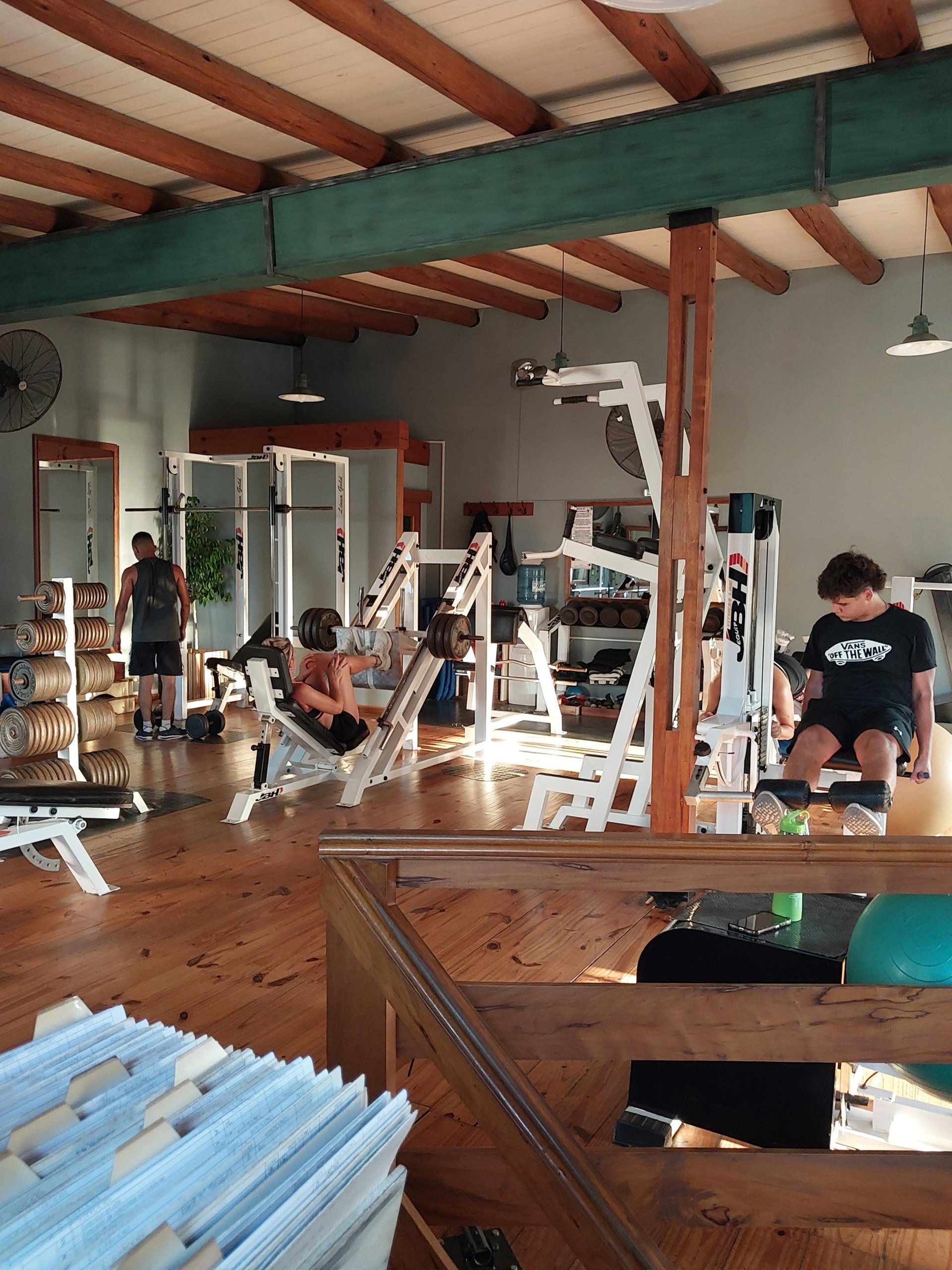 topless man in black shorts carrying black dumbbell