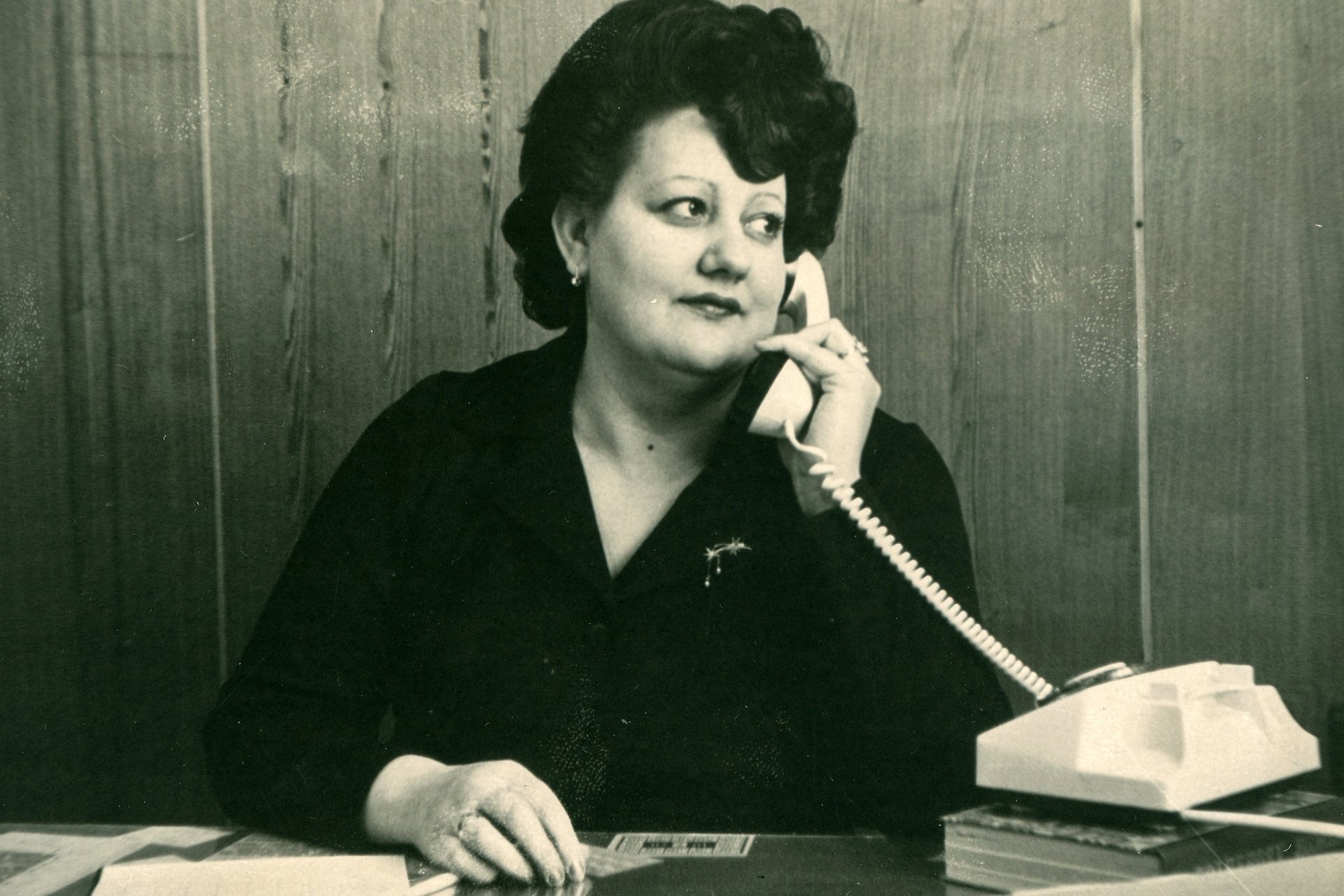 black and brown rotary phone near gray wall