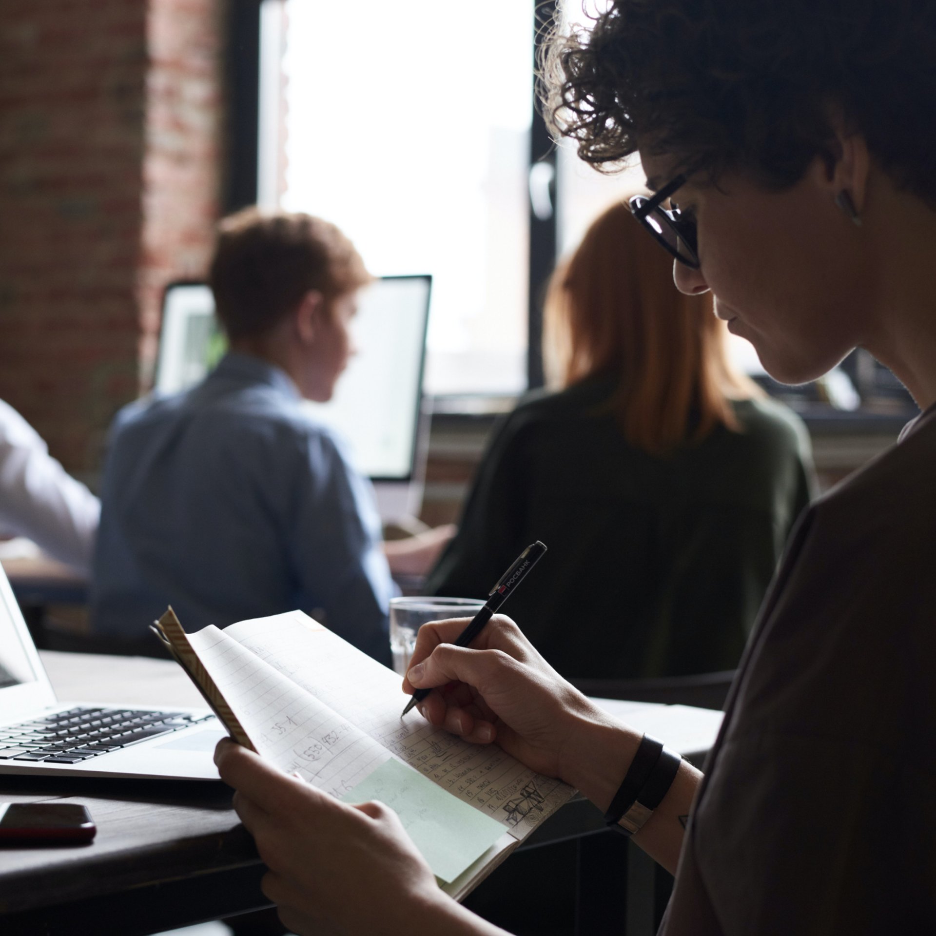 man and woman sitting on bench facing sea