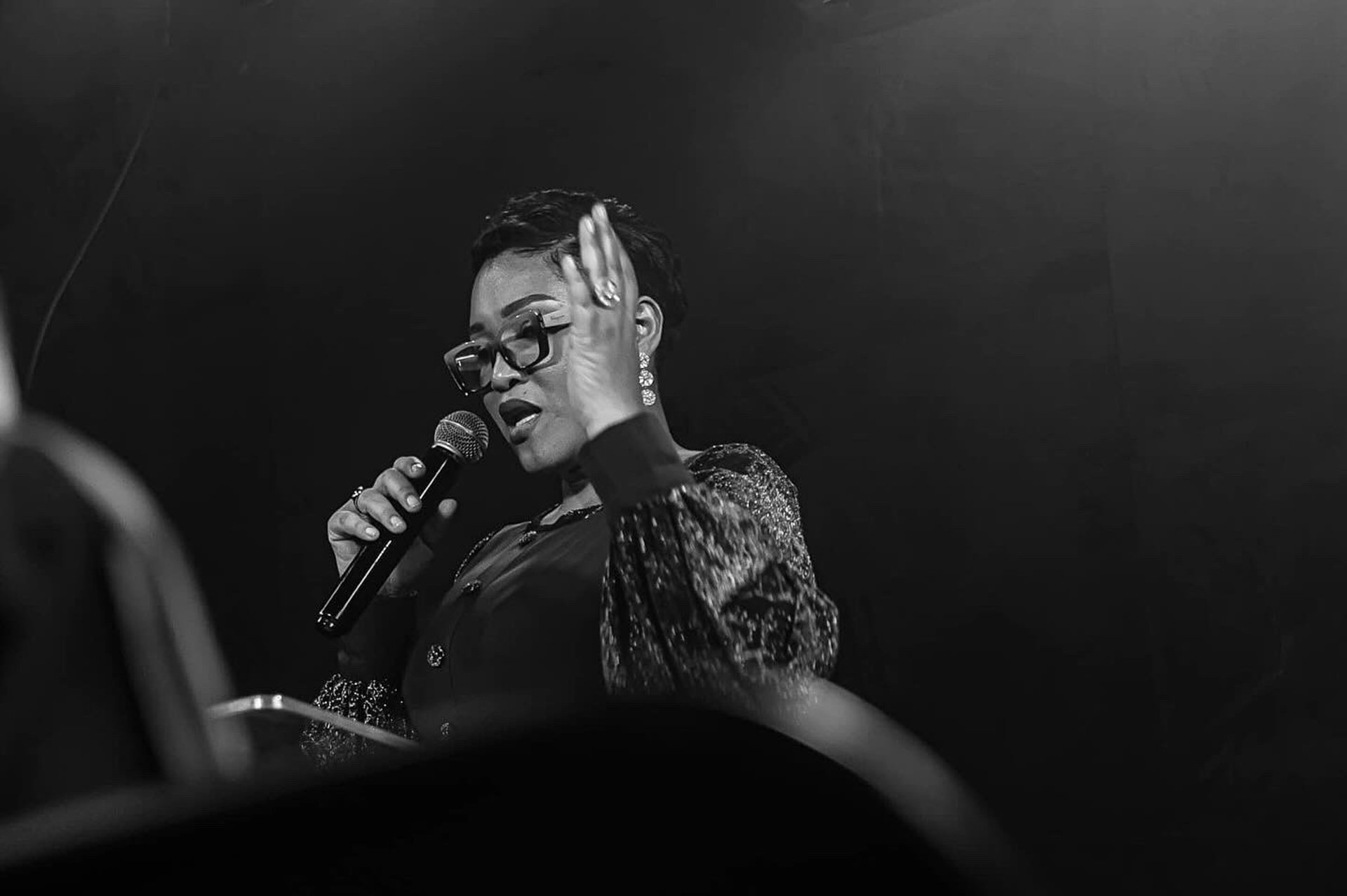 man in orange top beside eyeglasses on brown book