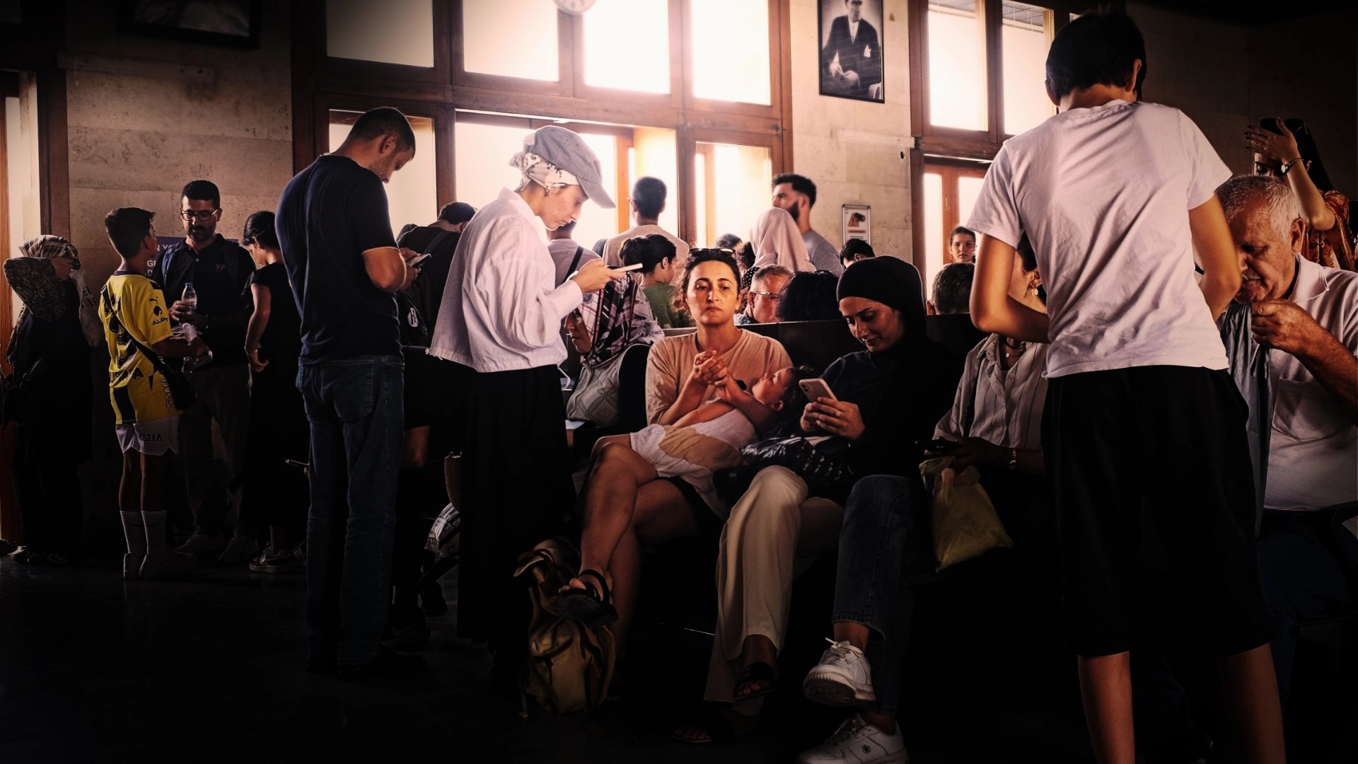 Waiting room for ferry with people reading phones
