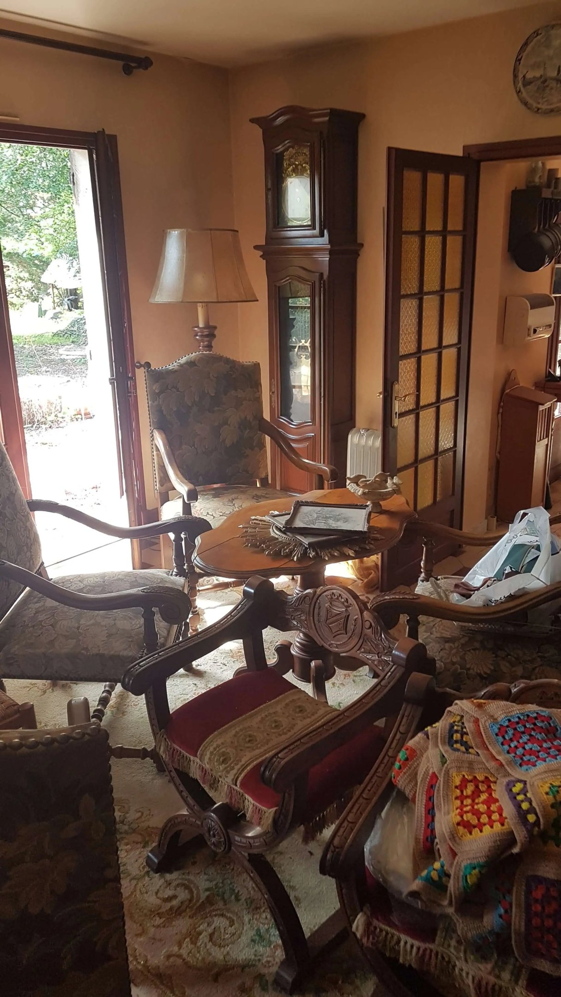 Brocante Lepeltier - Un salon décoré avec un canapé, une chaise, une table et une horloge au mur.