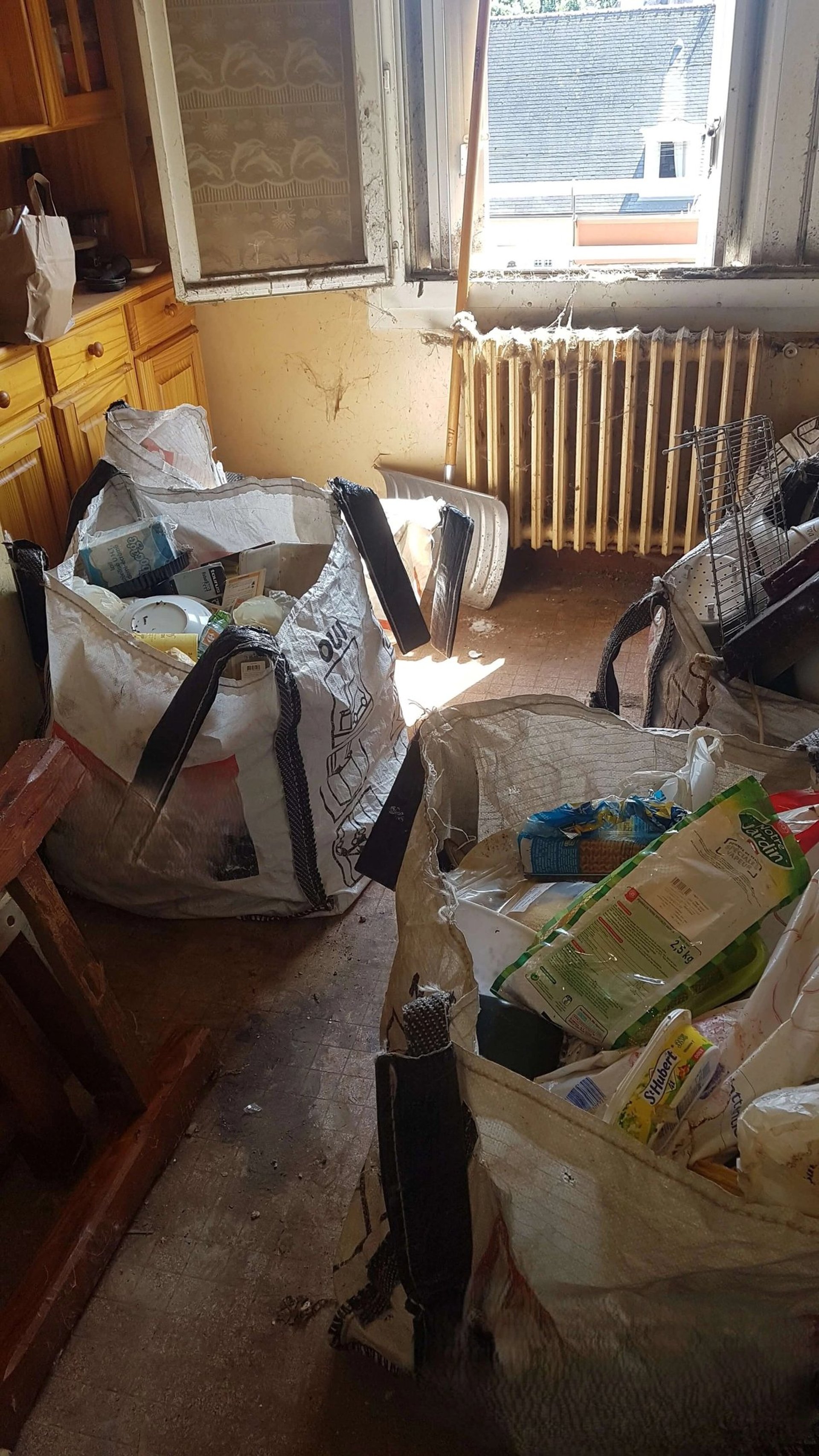 Débarras Lepeltier - Une salle encombrée de sacs avec une fenêtre offrant une vue extérieure.
