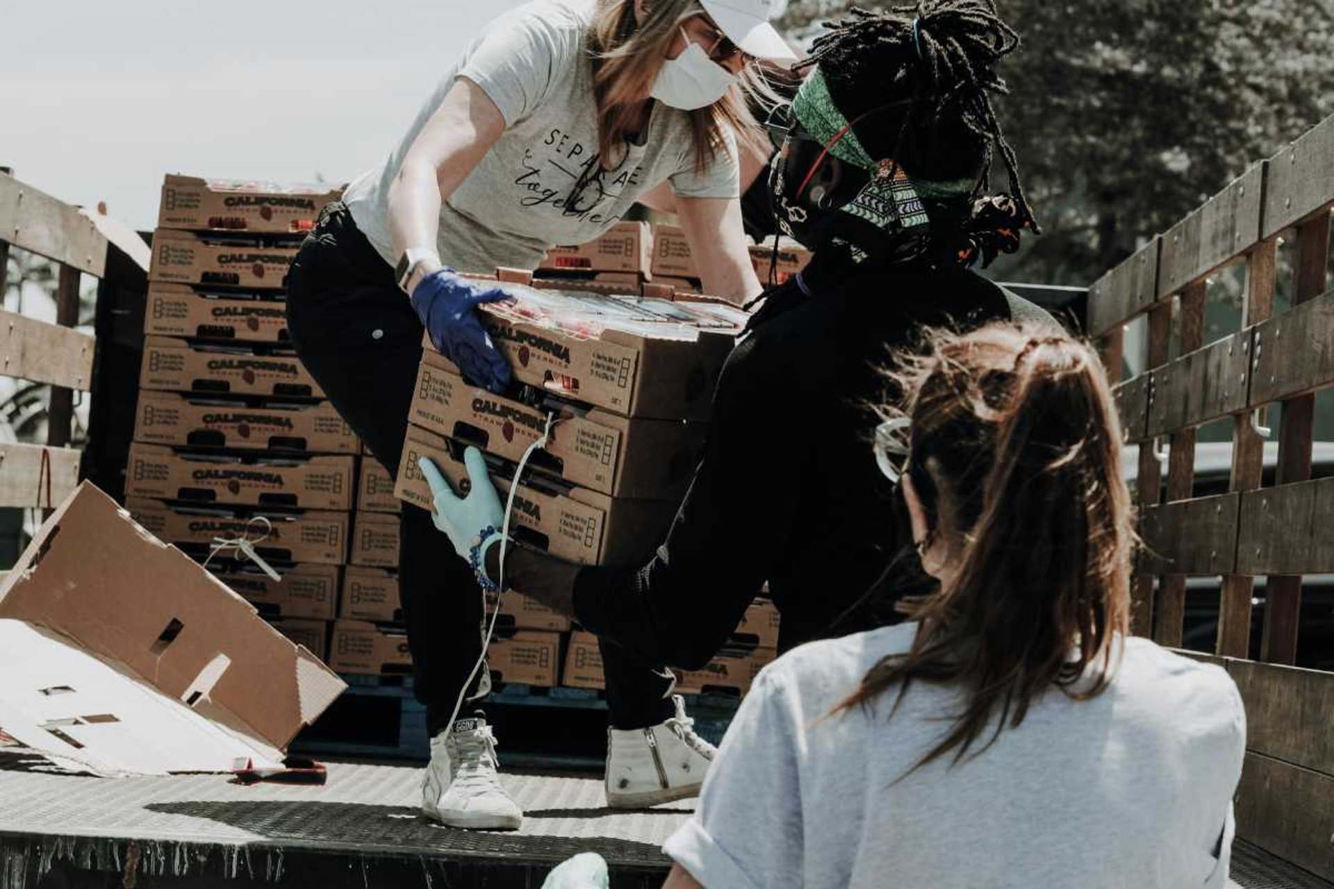 voluntarios ayudando a distribuir mercancia que acaba de llegar al banco de alimentos