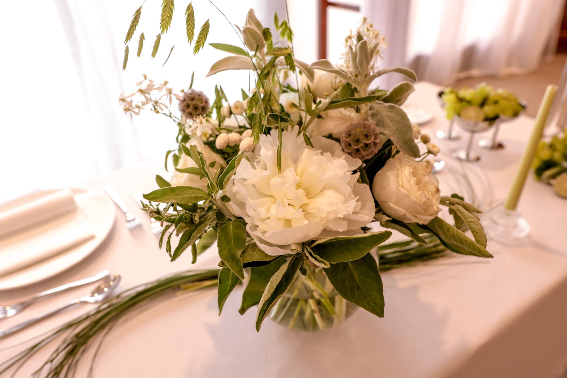 a table topped with lots of vases filled with flowers