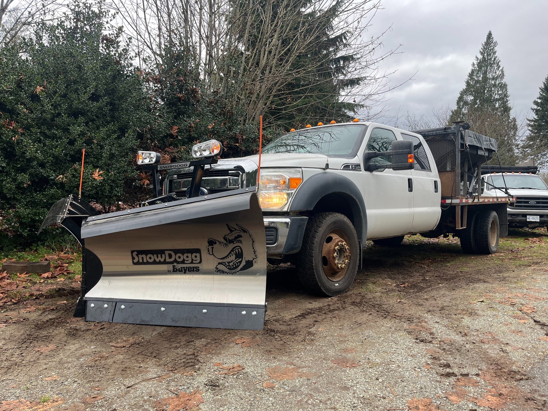 a white truck with a silver V plow blade