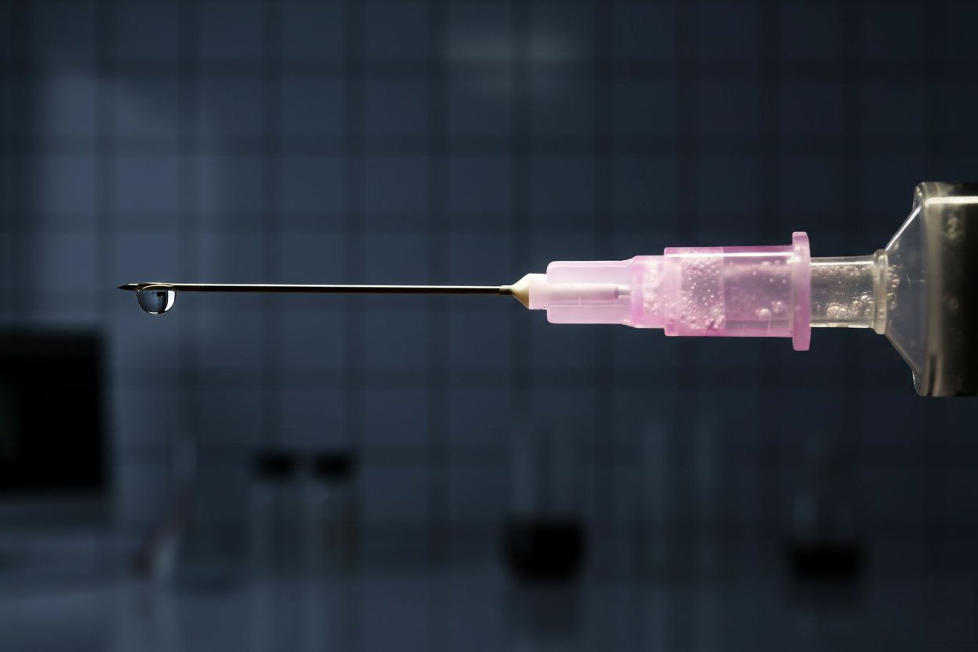 Medical supplies including pills, syringe, and scissors on blue.