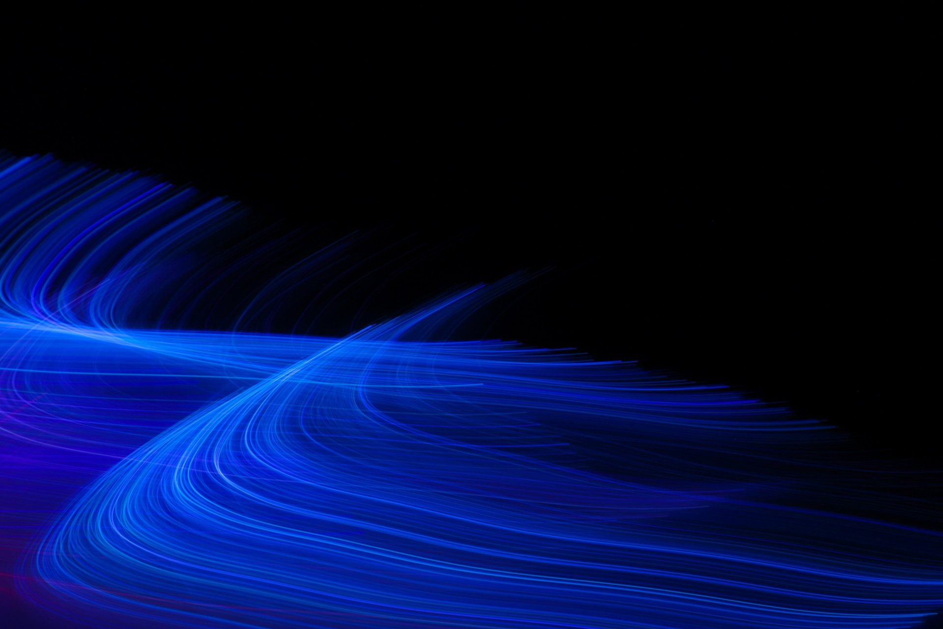 an abstract photo of a curved building with a blue sky in the background