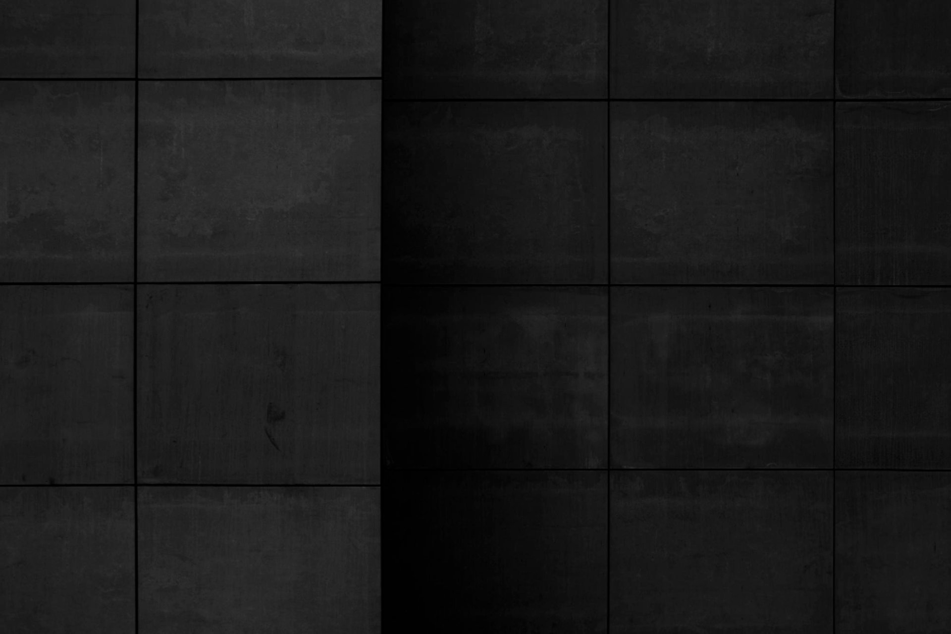 a close up of a bathroom wall with black tiles