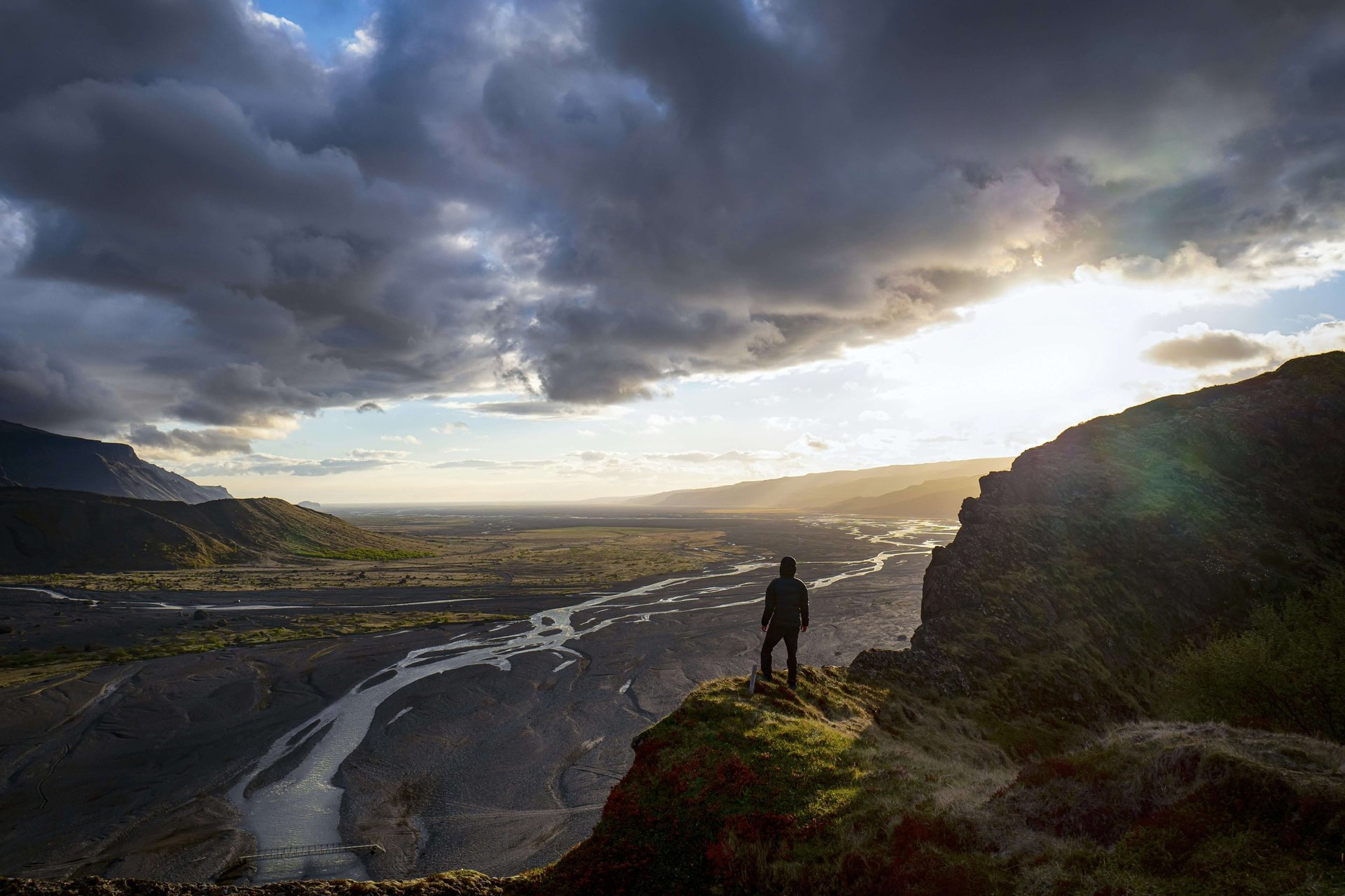 man-standing-on-high-ground-overlooking-landscape-representing-awareness-and-real-world-survival-preparedness