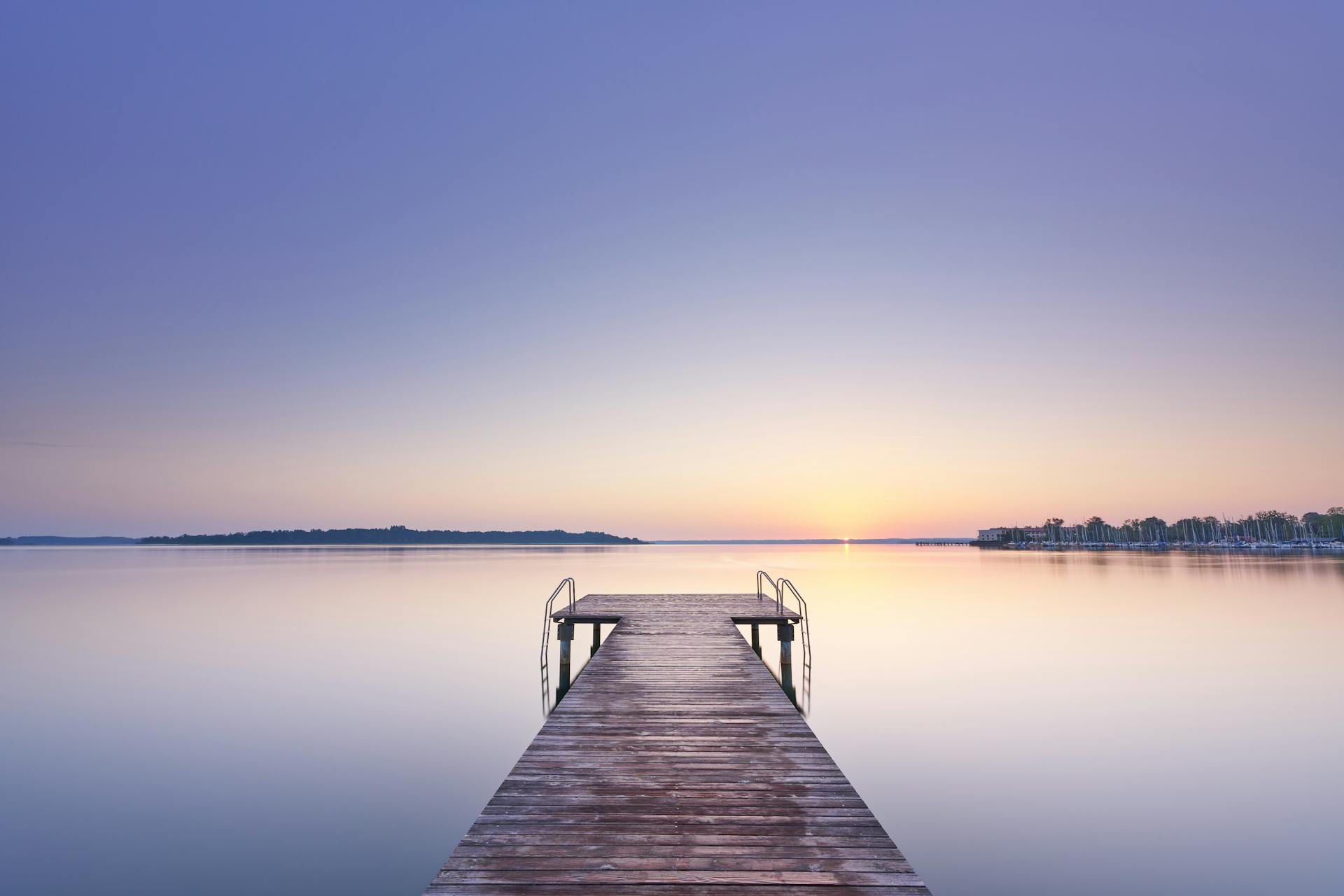 A long dock extends into the water at sunset