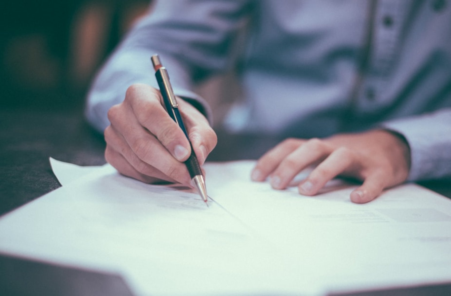 man writing on paper
