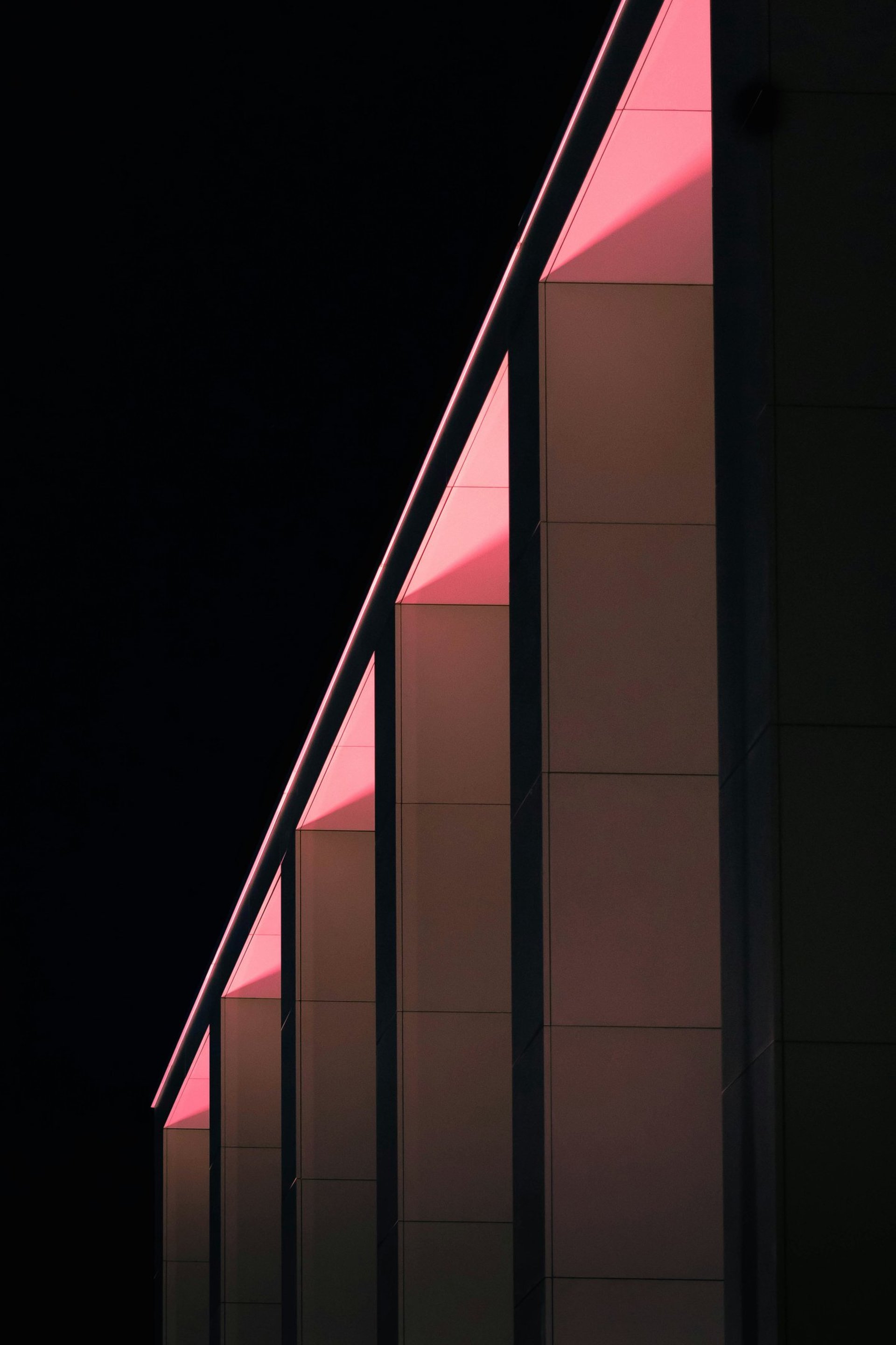 an abstract photo of a curved building with a blue sky in the background