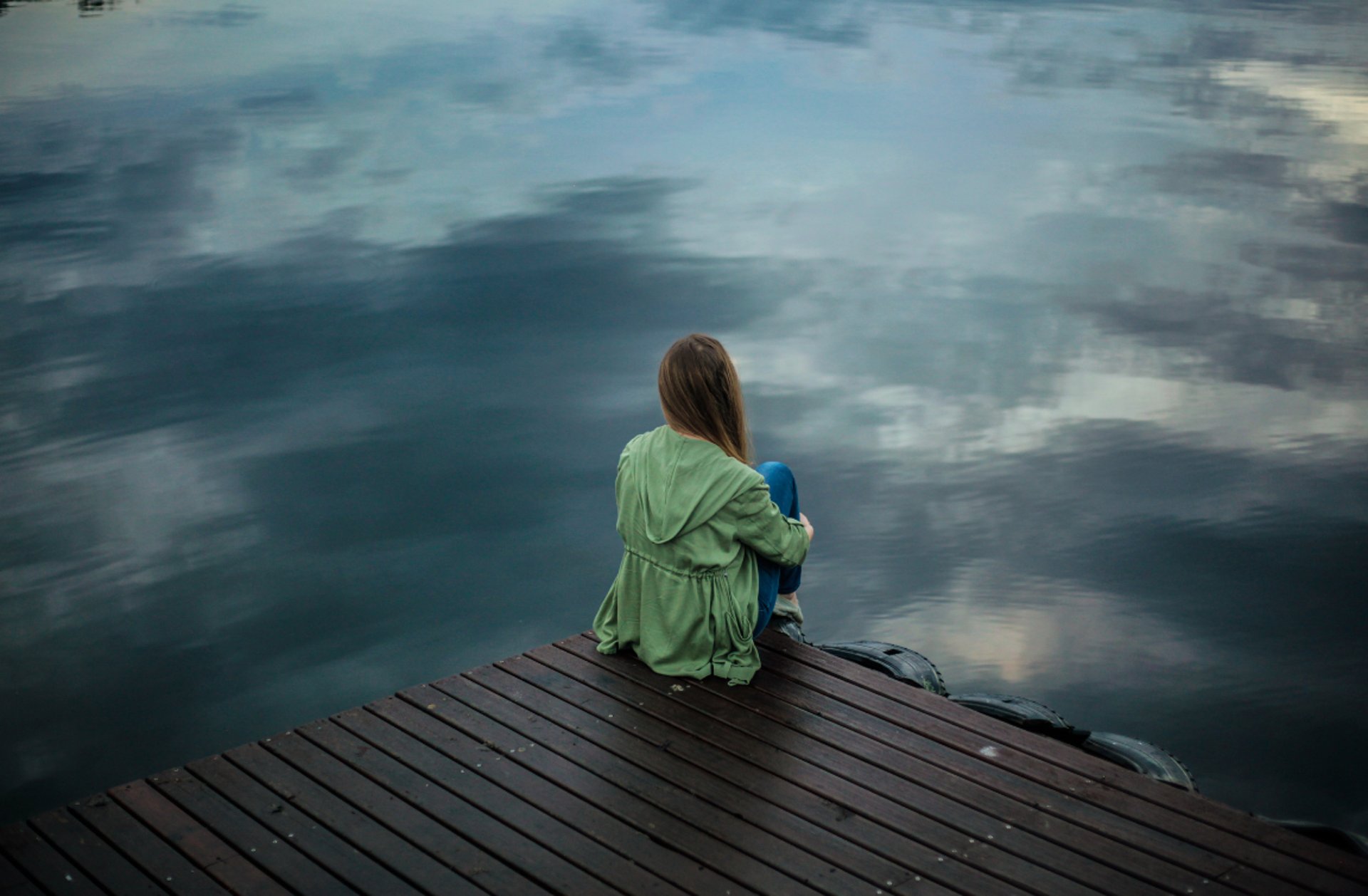 woman wearing gray long-sleeved shirt facing the sea