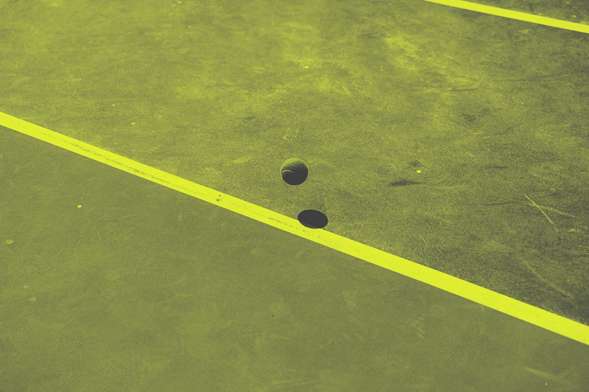 a tennis racket and four tennis balls on a court