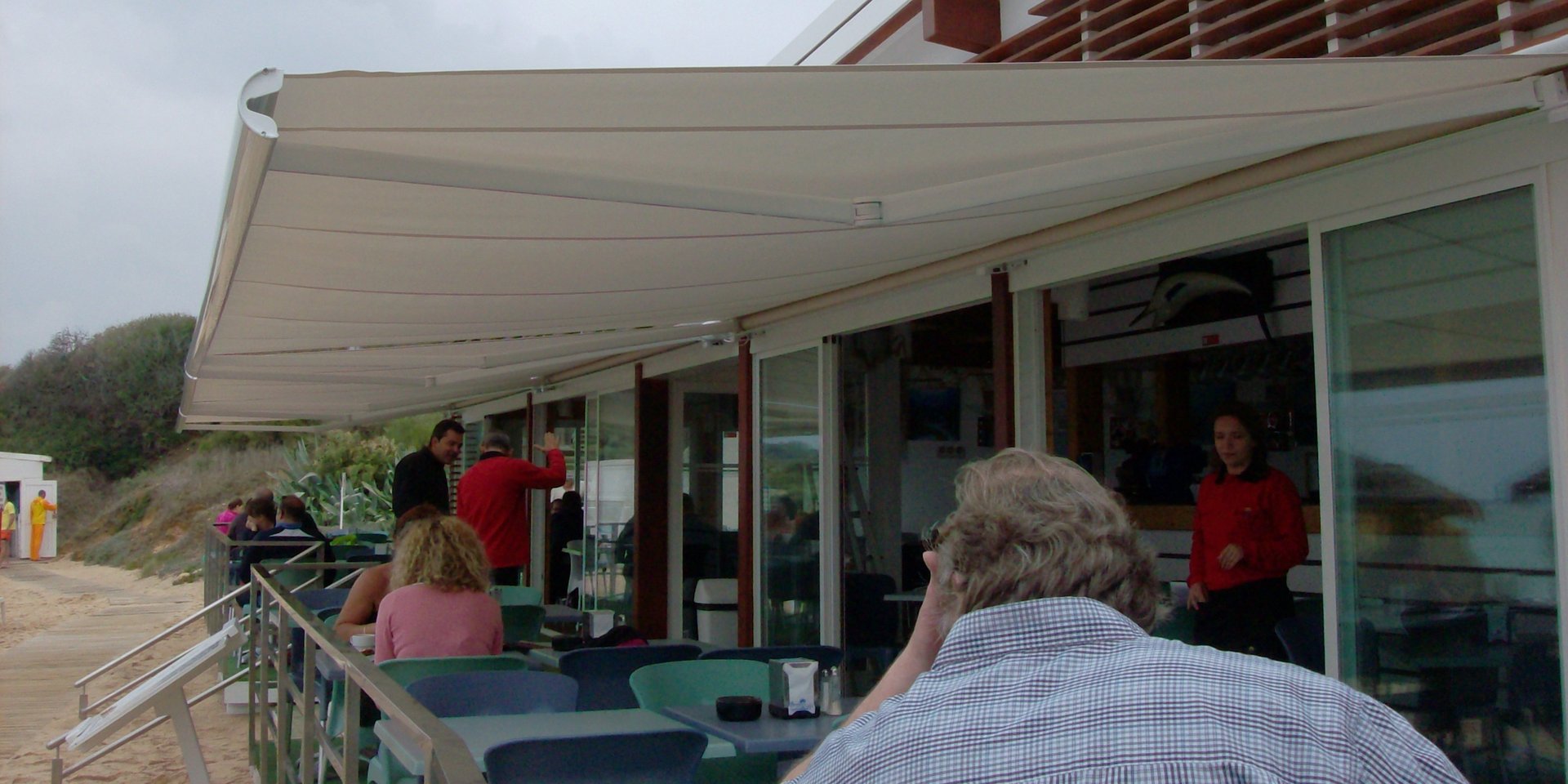 A restaurant with tables and umbrellas outside at night
