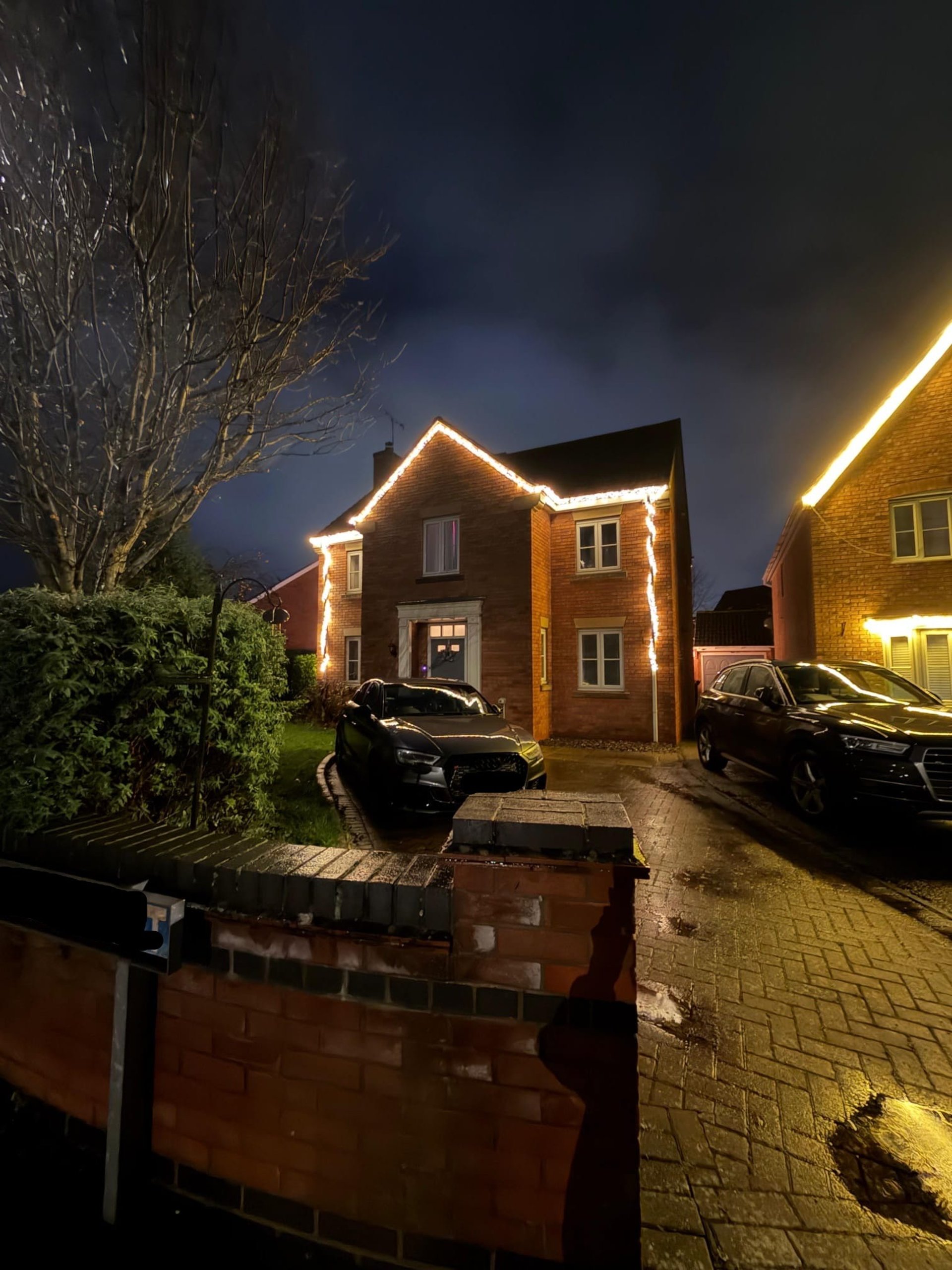 Christmas lights on house with car on drivway