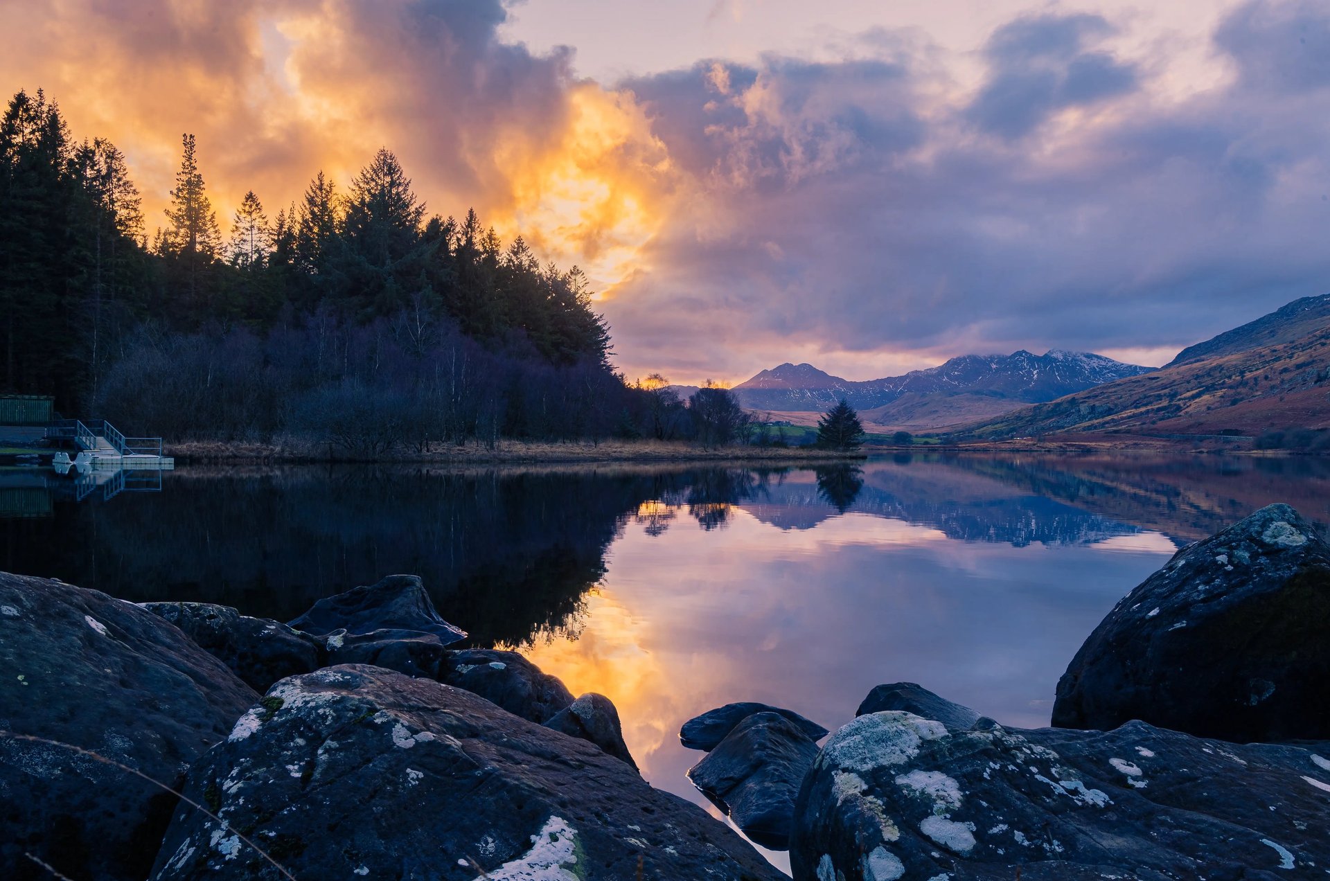sunset across lake mountains in background with snow
