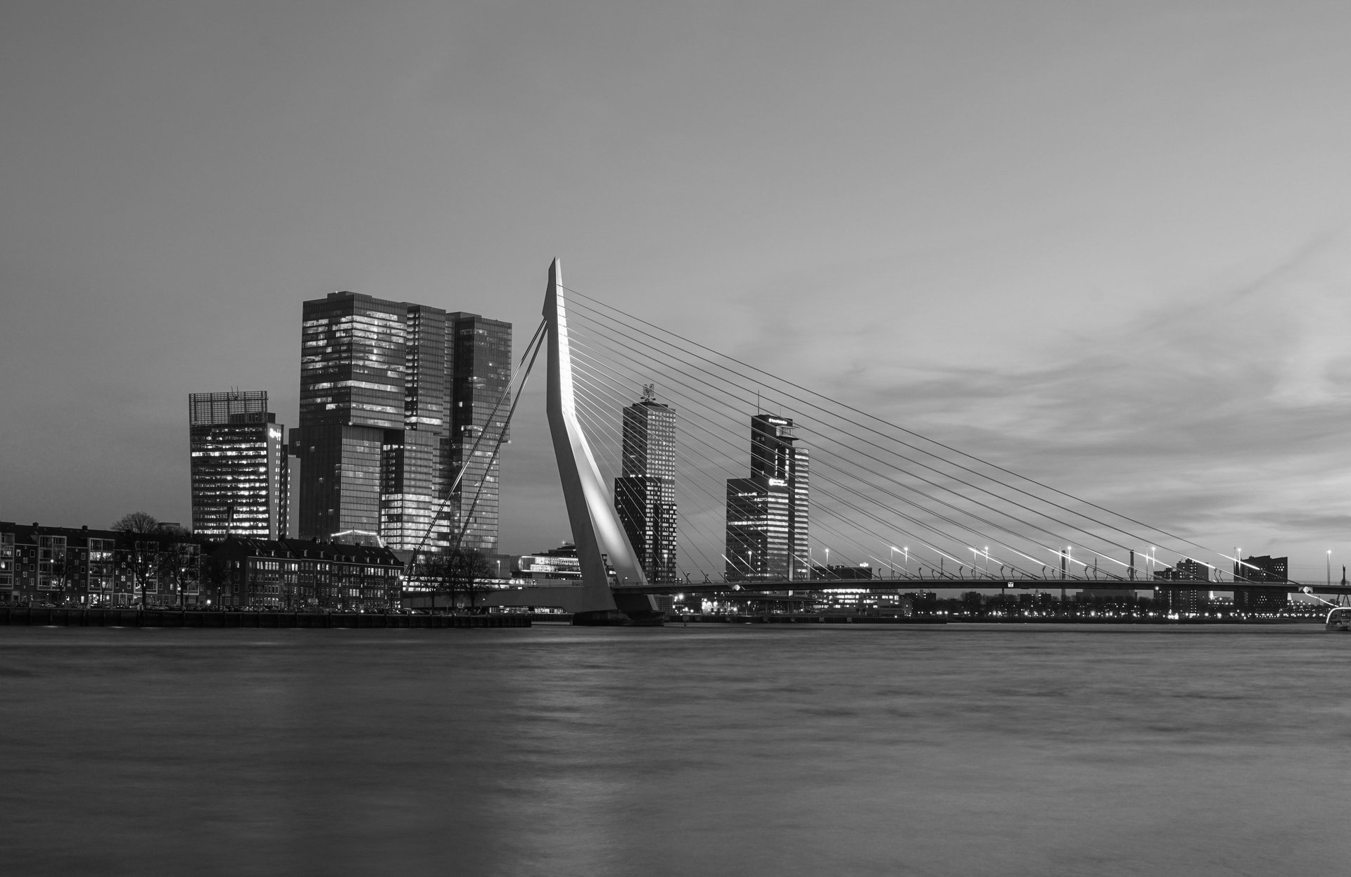 a bridge over a body of water with buildings in the background