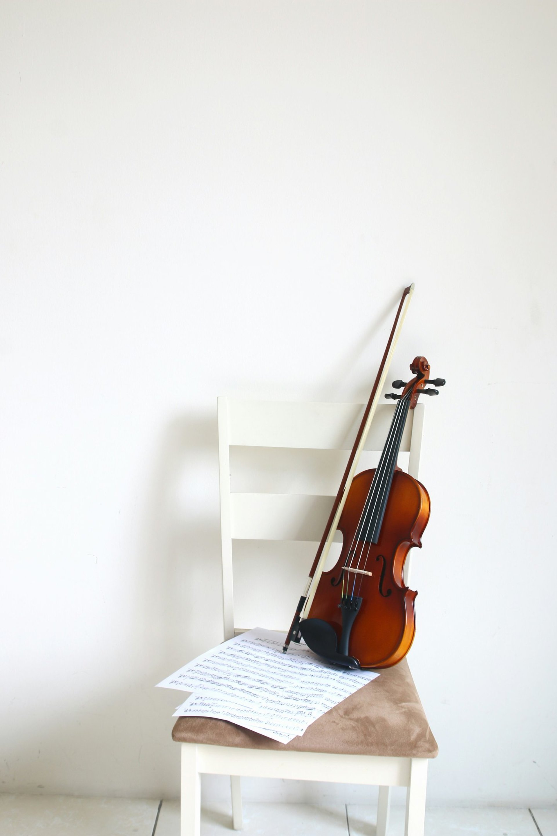 a violin sitting on top of a white chair