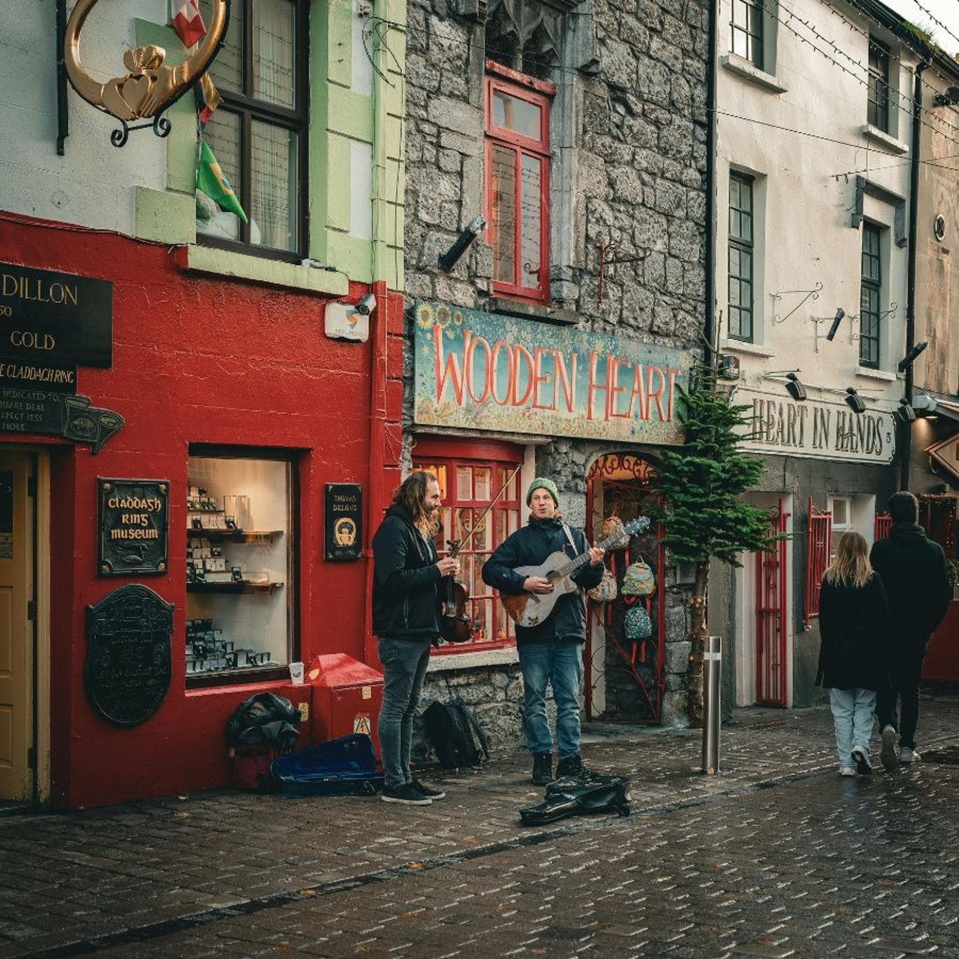a group of people walking down a street next to a tall building
