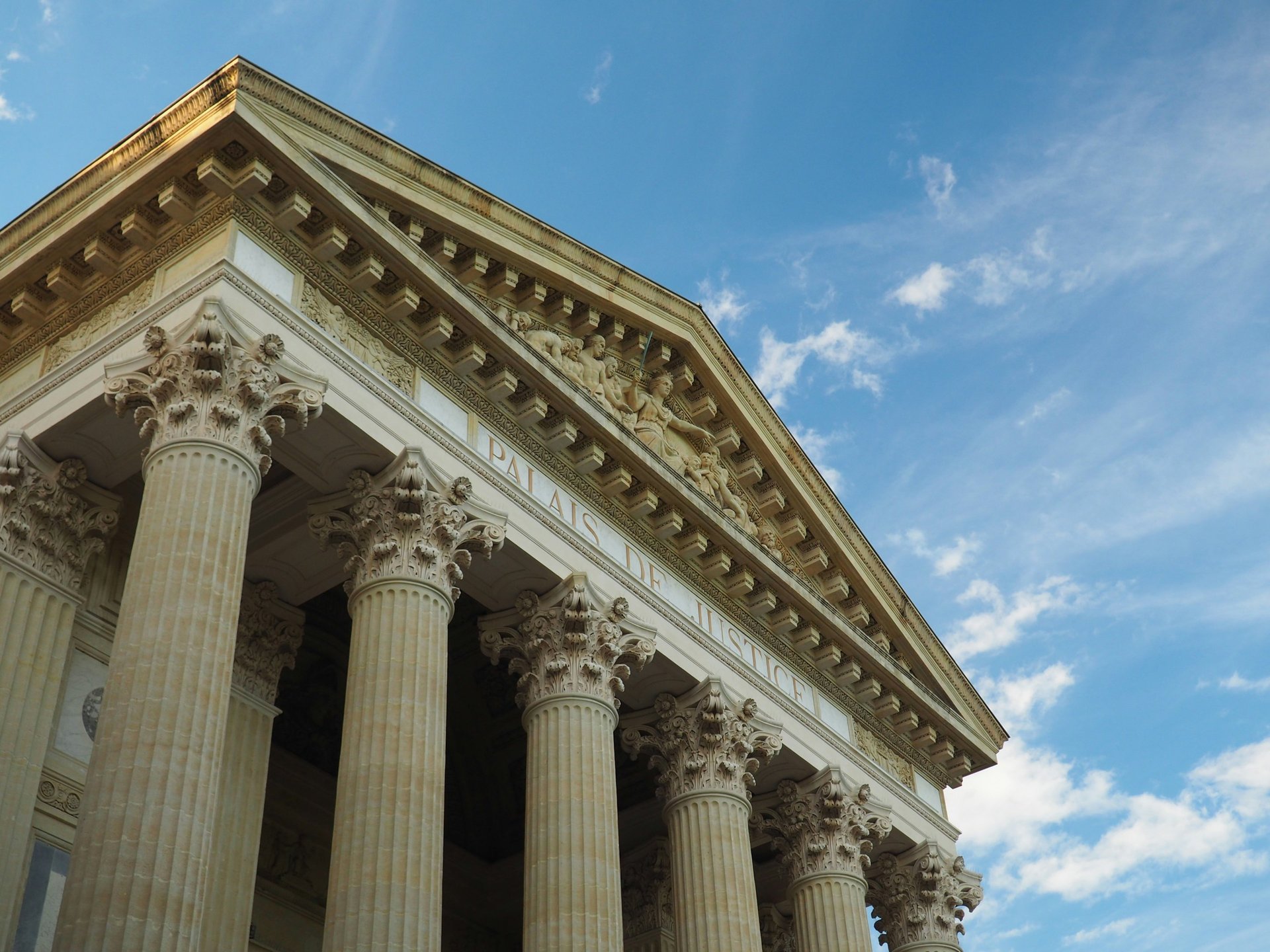 a tall building with columns and a sky background