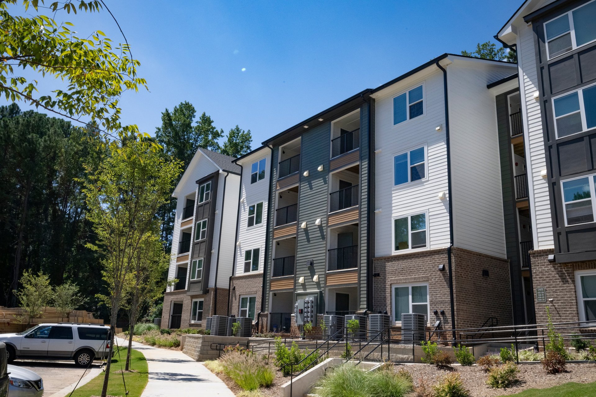 Aerial view of apartment buildings, parking, and landscaped green space at Arrogate Village in Summerville, SC.