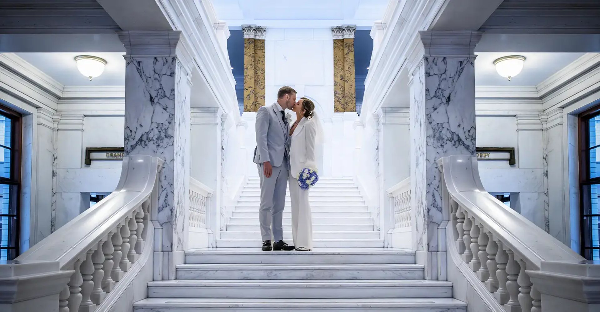 wedding couple standing on the steps inside Camden Town Hall