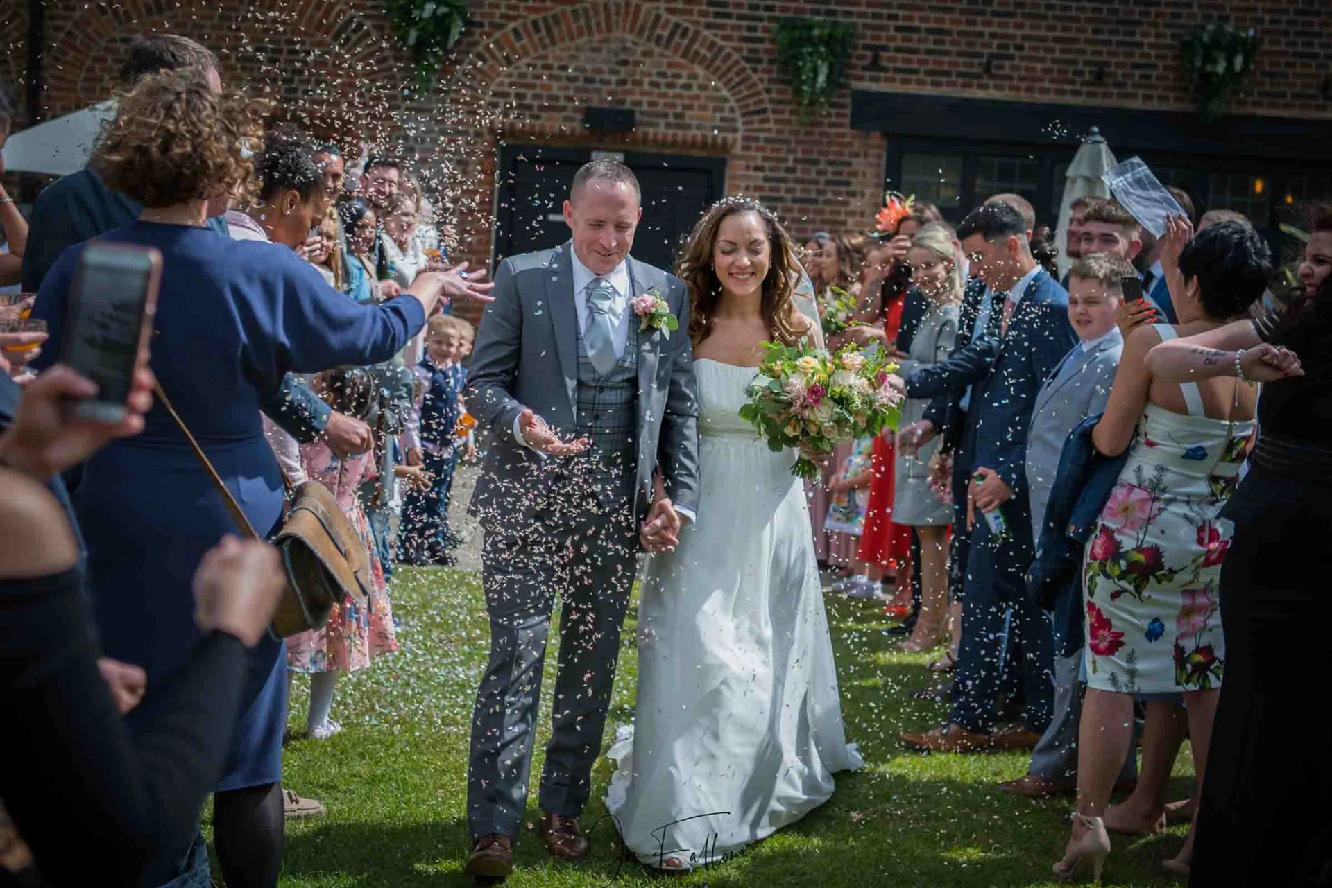 wedding couple running through confetti