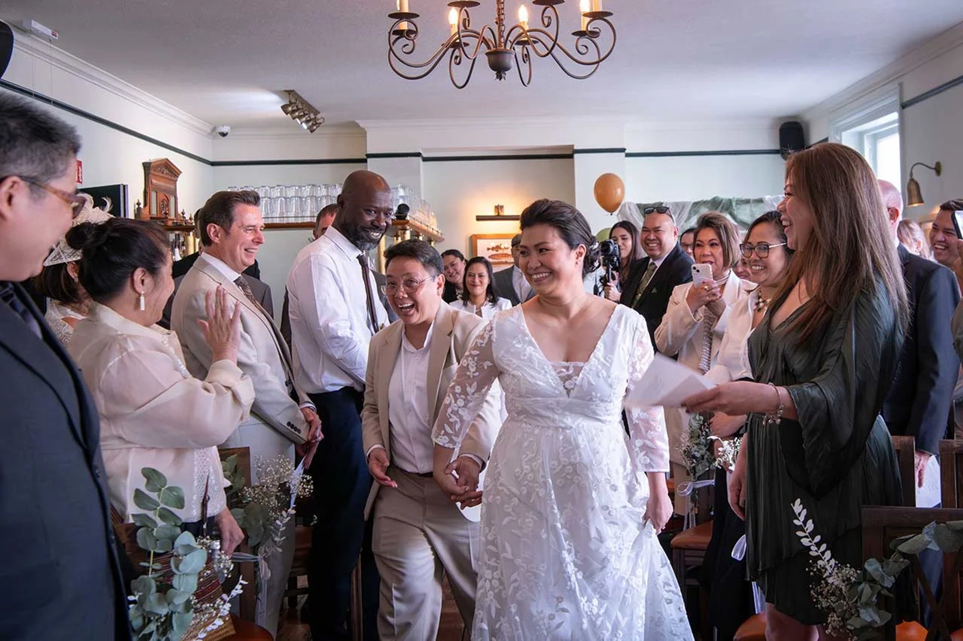 wedding couple walking down the aisle being cheered on by friends and family