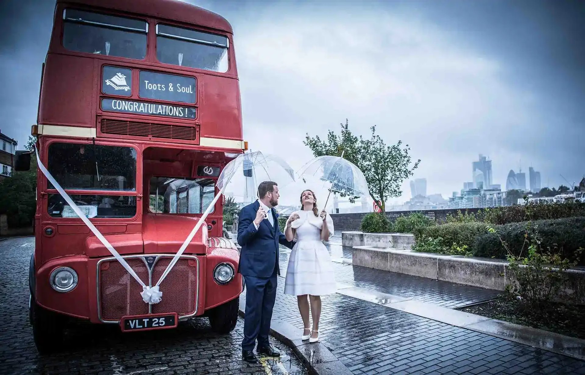 bride and Groom standing in front of a London red bus