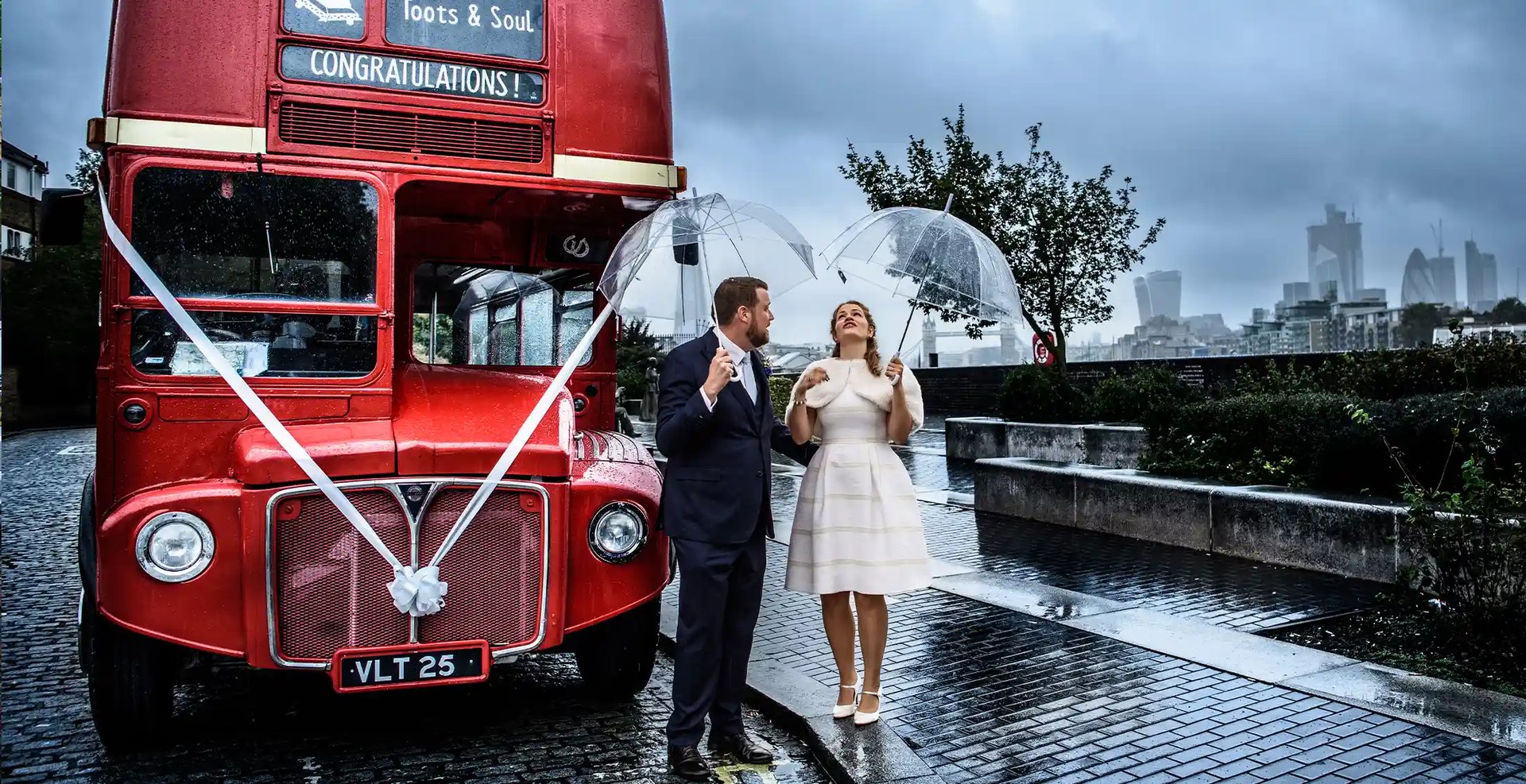 newly-weds standing next to a red london bus