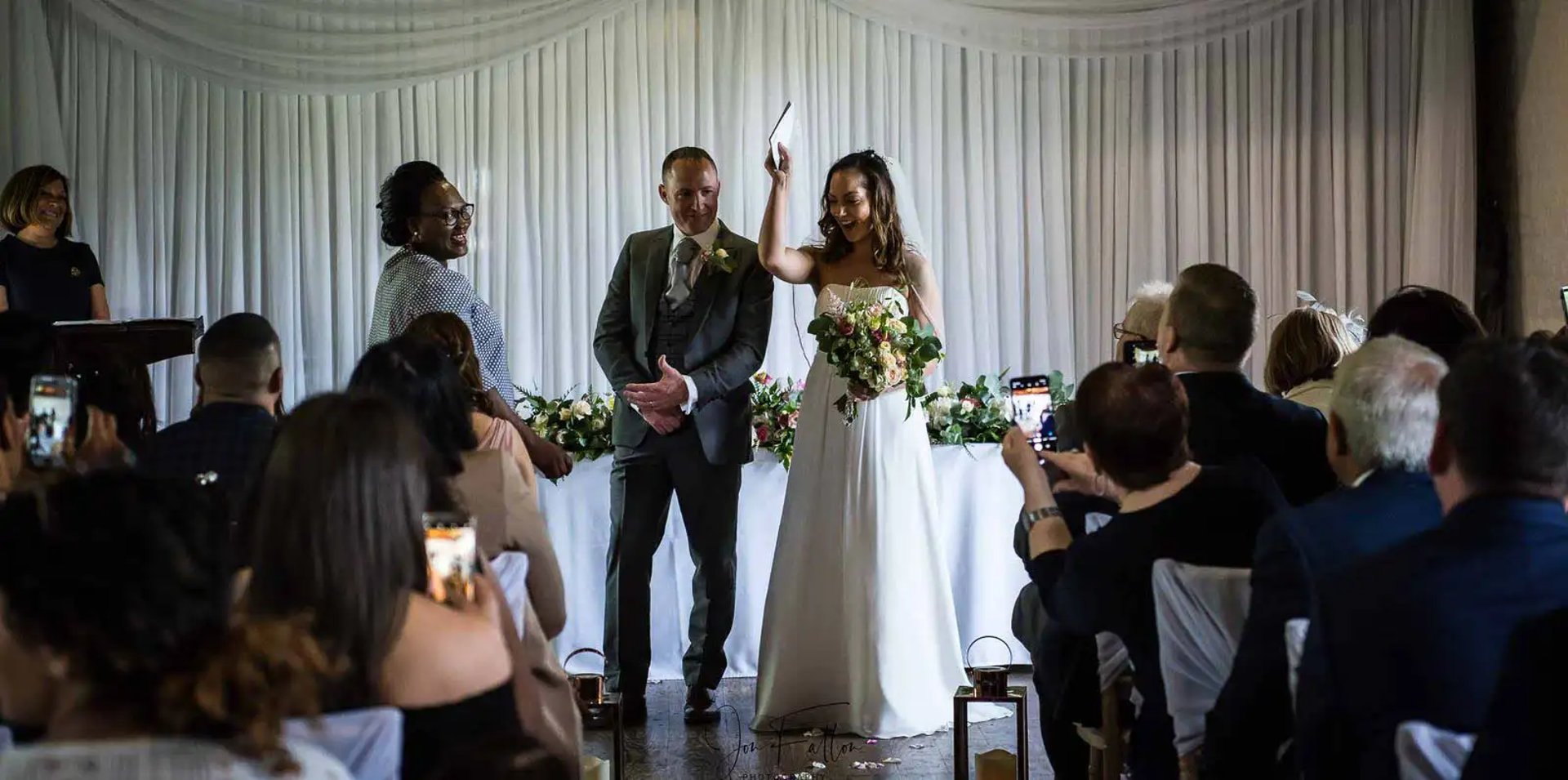 newly-weds holding their wedding certificate in the air