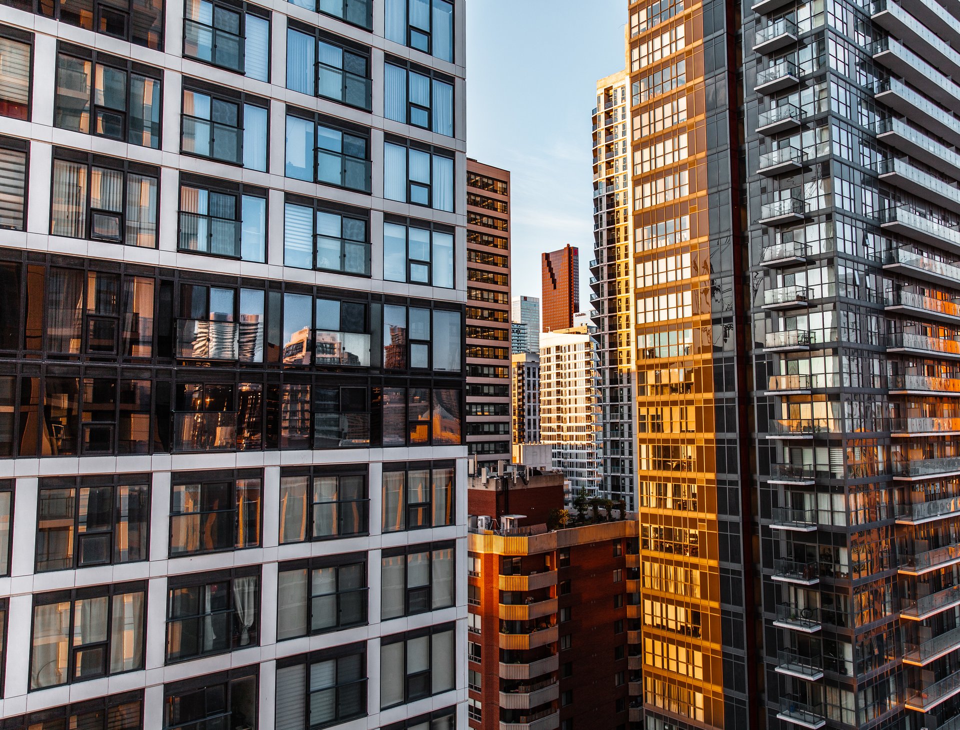 low angle photography of high rise building under white clouds during daytime