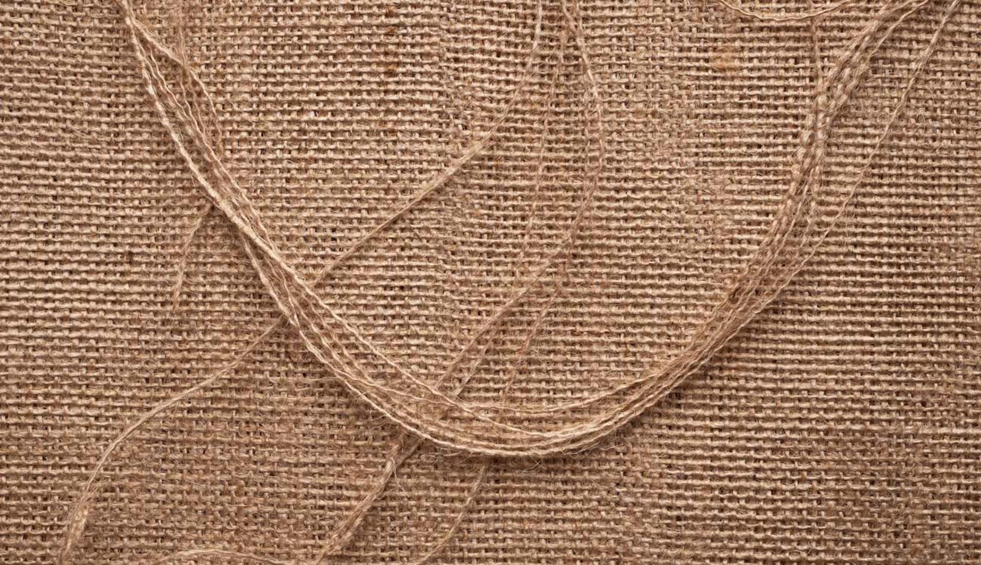 Textura de yute natural con hilos rústicos entrelazados.