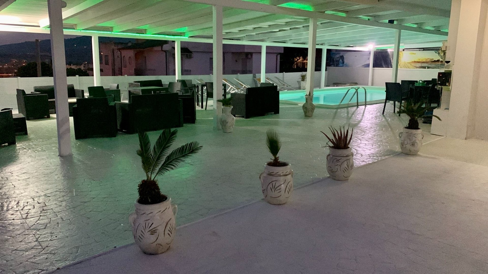 a pool with chairs and a table by it with flowers on the side