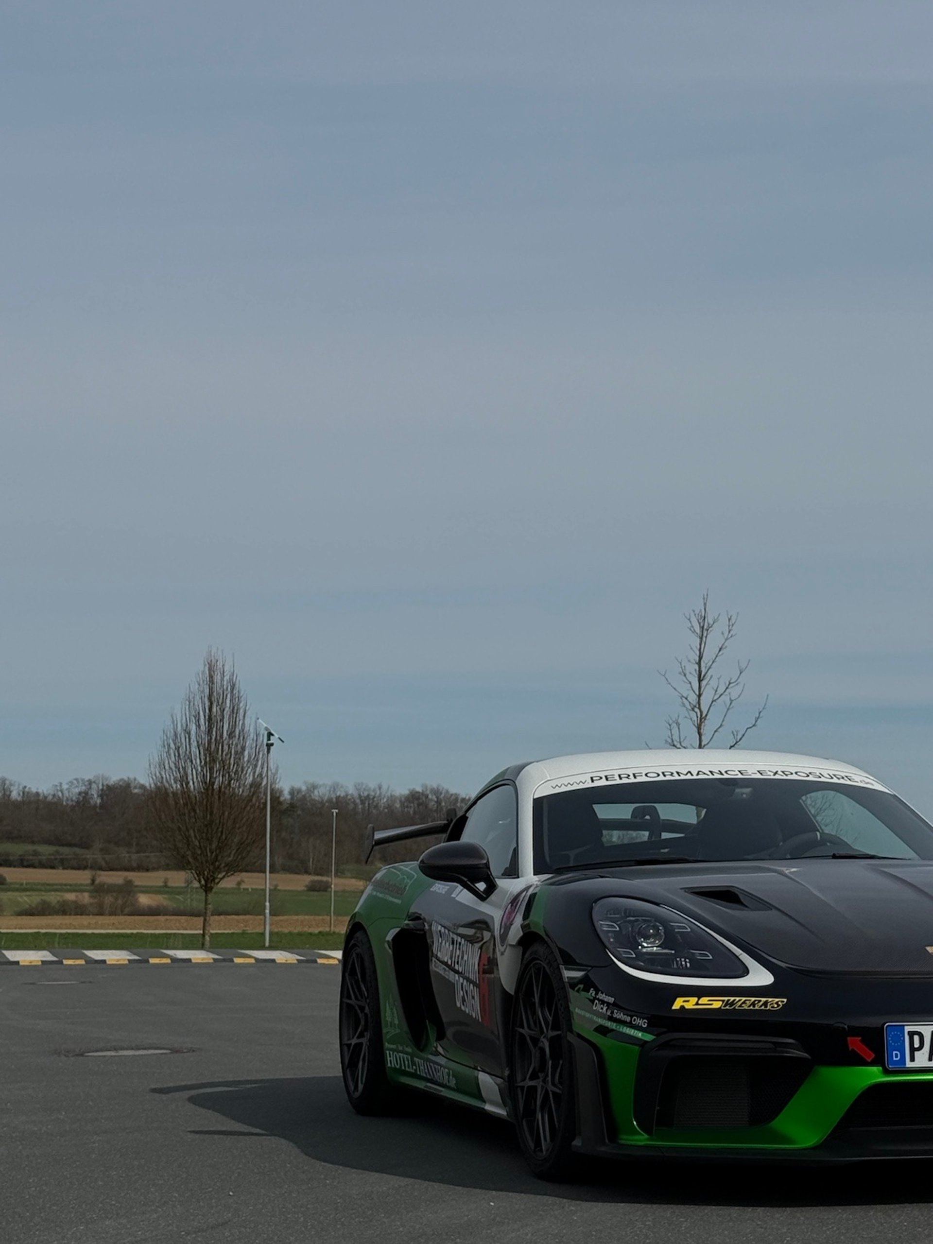 a grey porsche gtr parked in front of a building