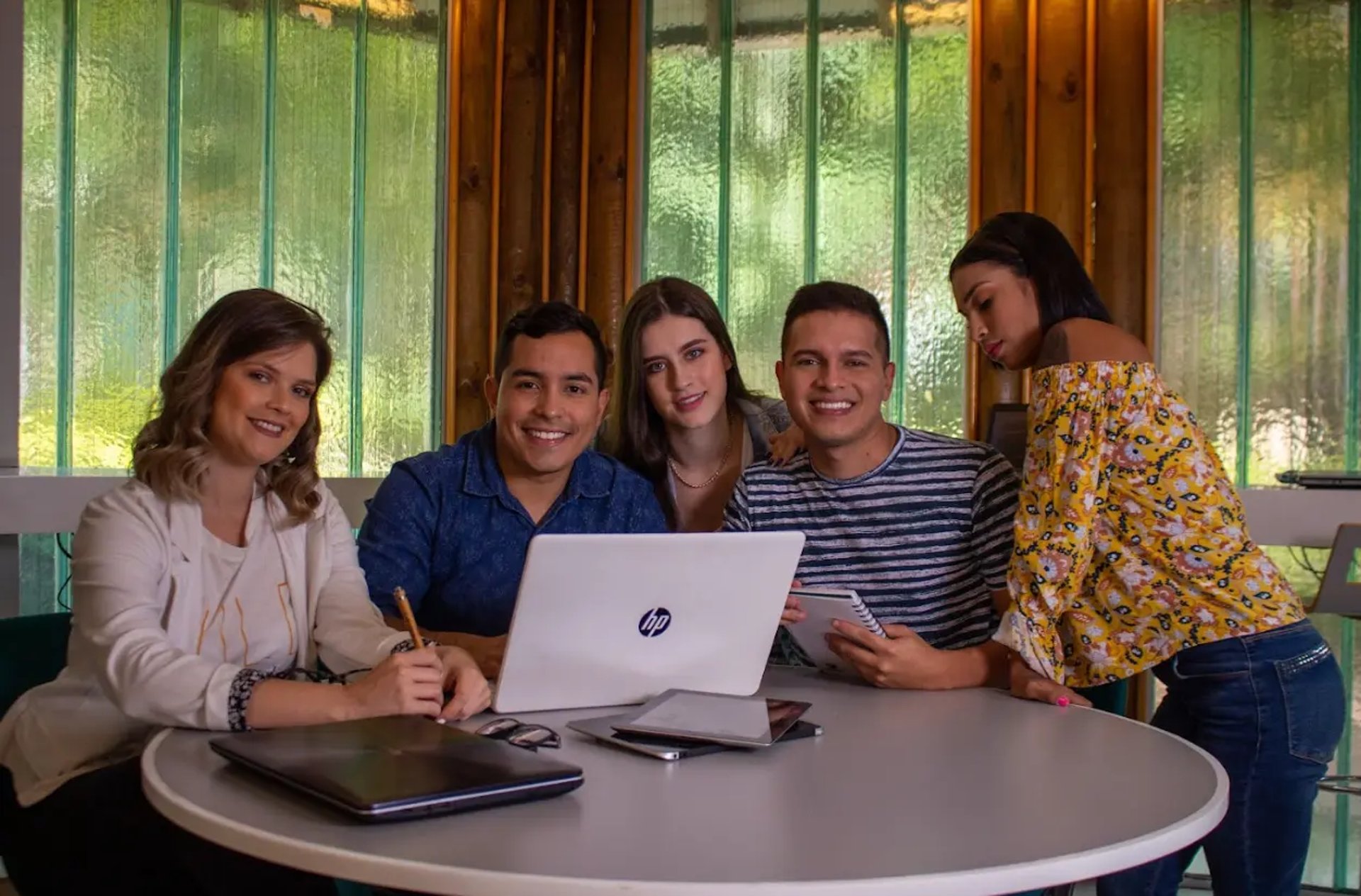 three people sitting in front of table laughing together