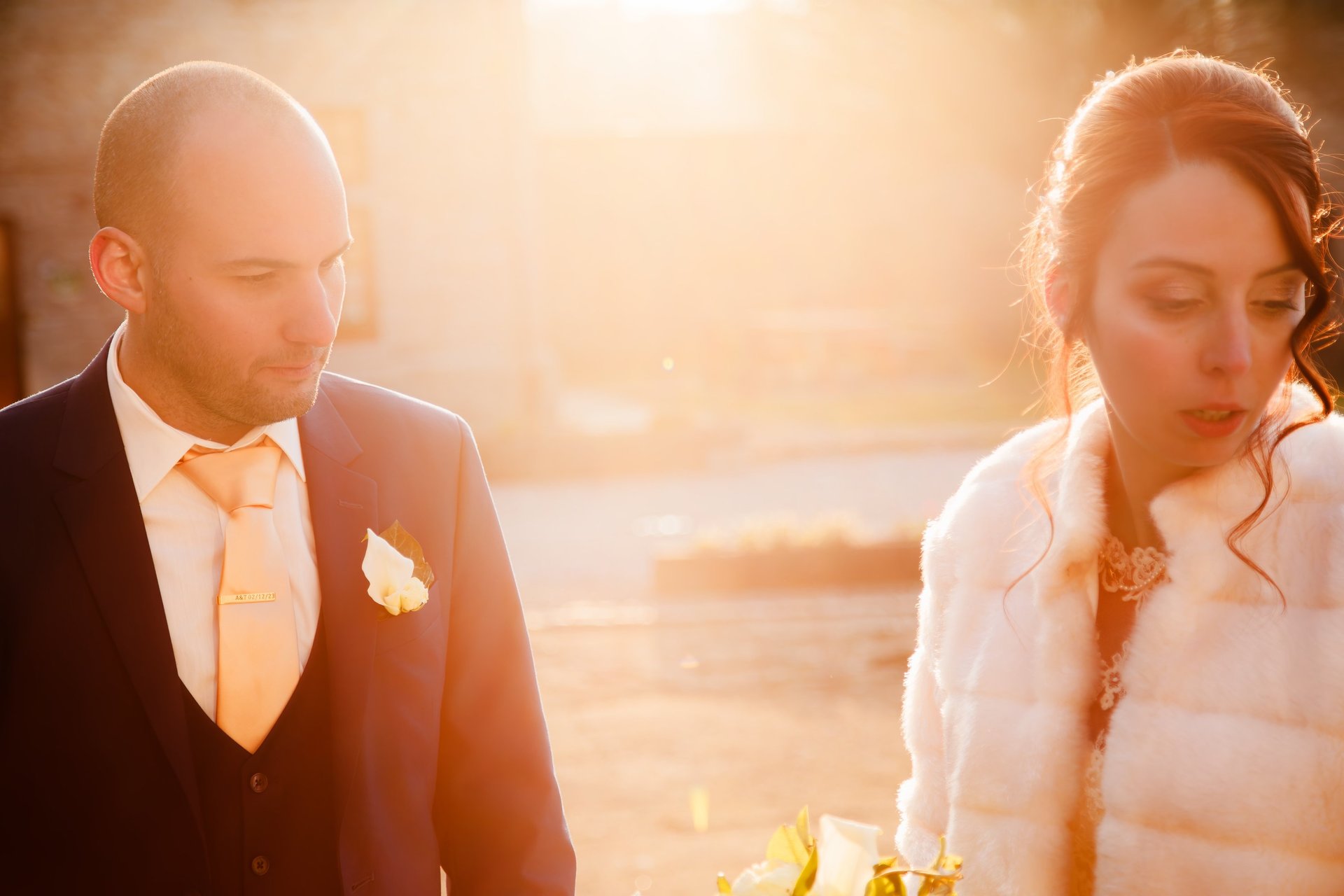 Un couple de mariés pose pour des photos de mariage en extérieur au coucher du soleil