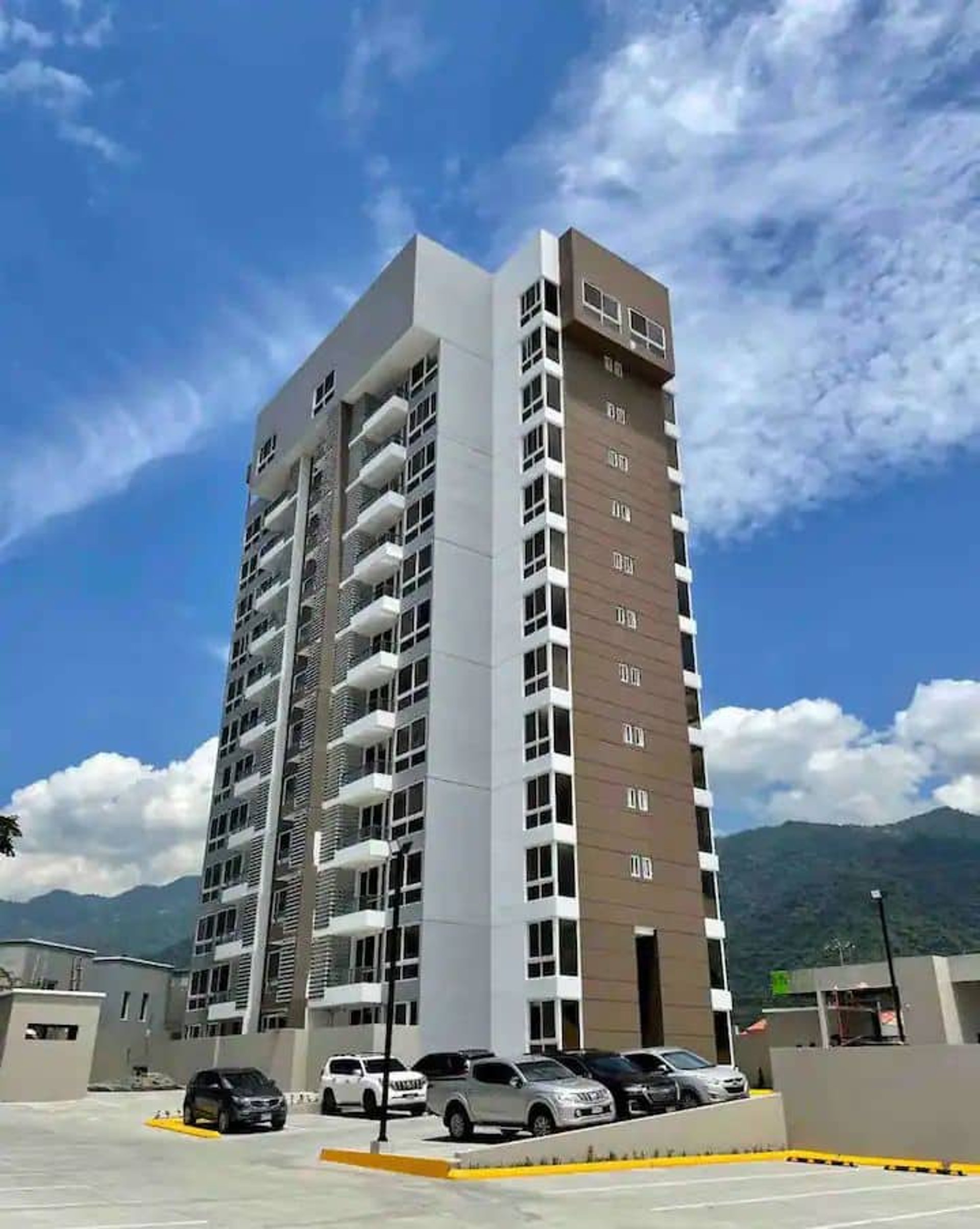 woman wearing yellow long-sleeved dress under white clouds and blue sky during daytime