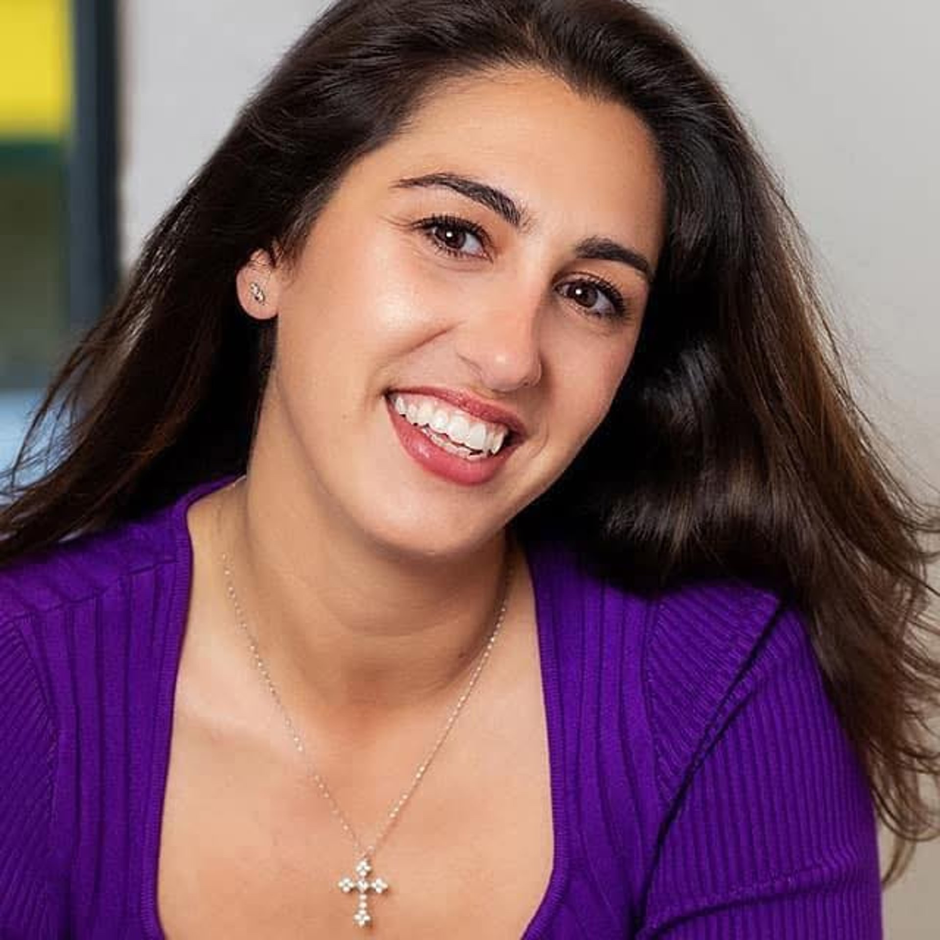 Woman singing into a microphone against a dark background